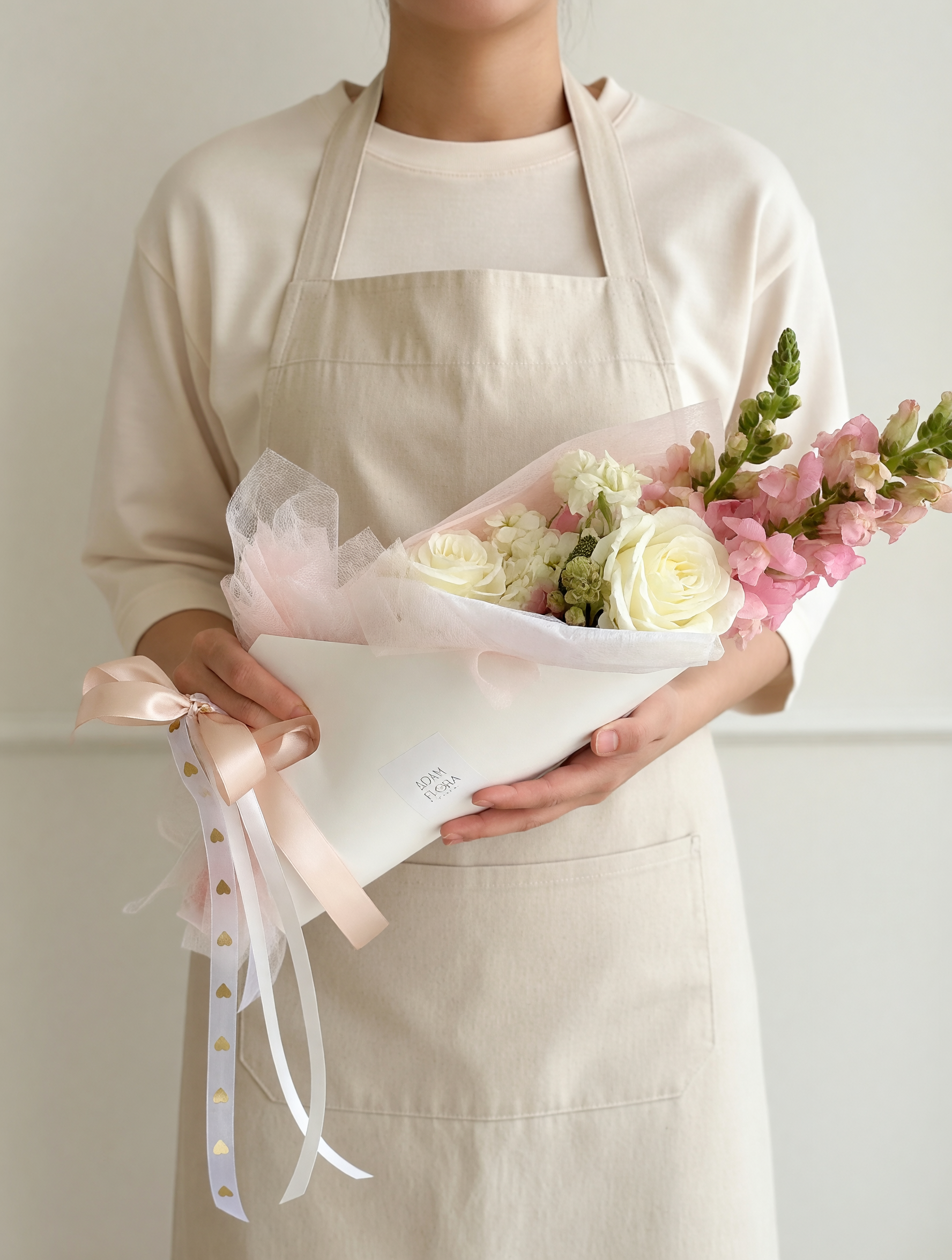 Mother's Day flowers in a hand held carrier, featuring fresh roses,stock,snapdragons florist arrangement available in Hamilton.
