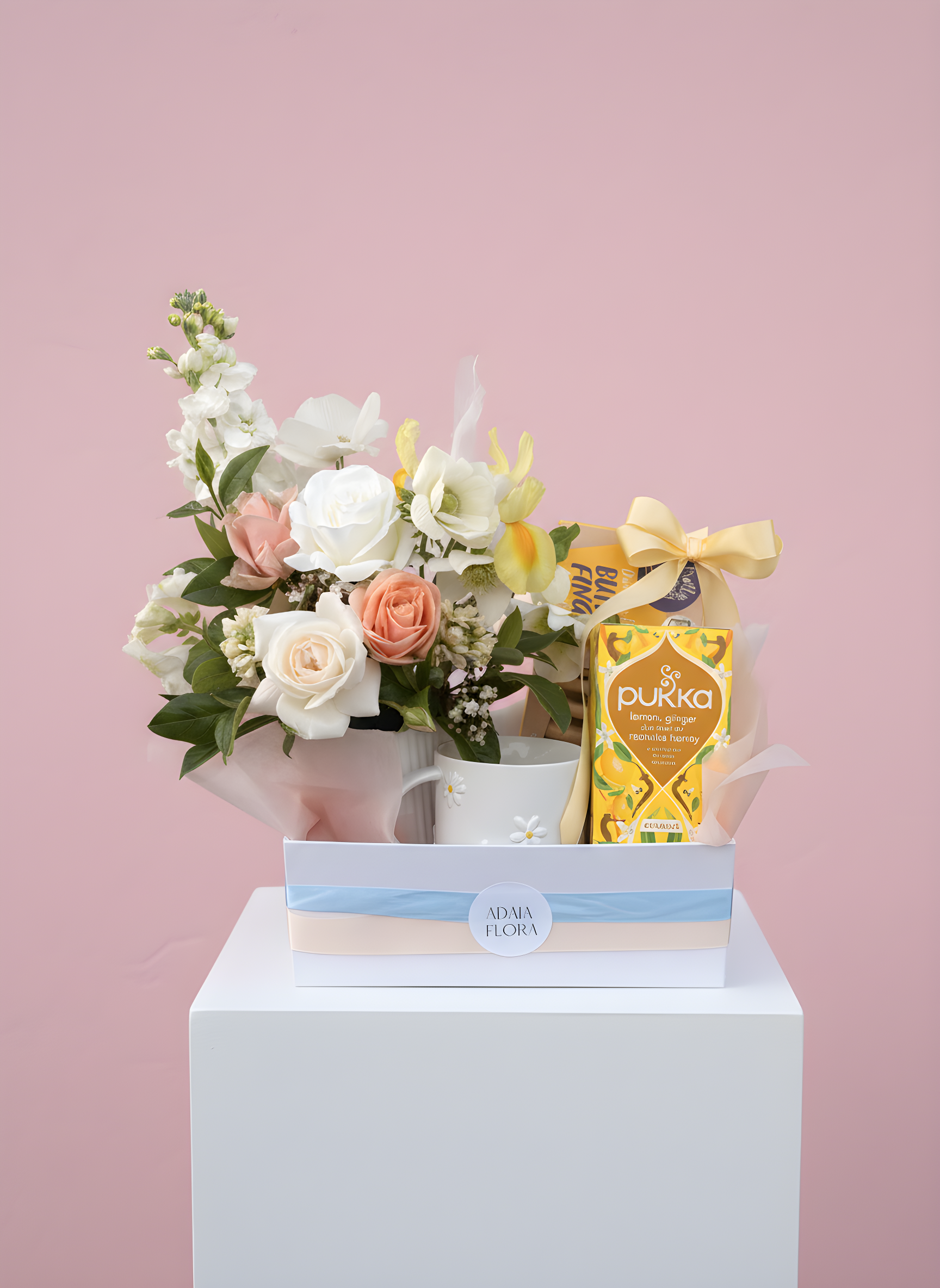 Blue Skies hamper by Adaia Flora featuring a fresh potted flower arrangement, daisy mug, lemon and honey tea,chocolate shortbread and sweet treats