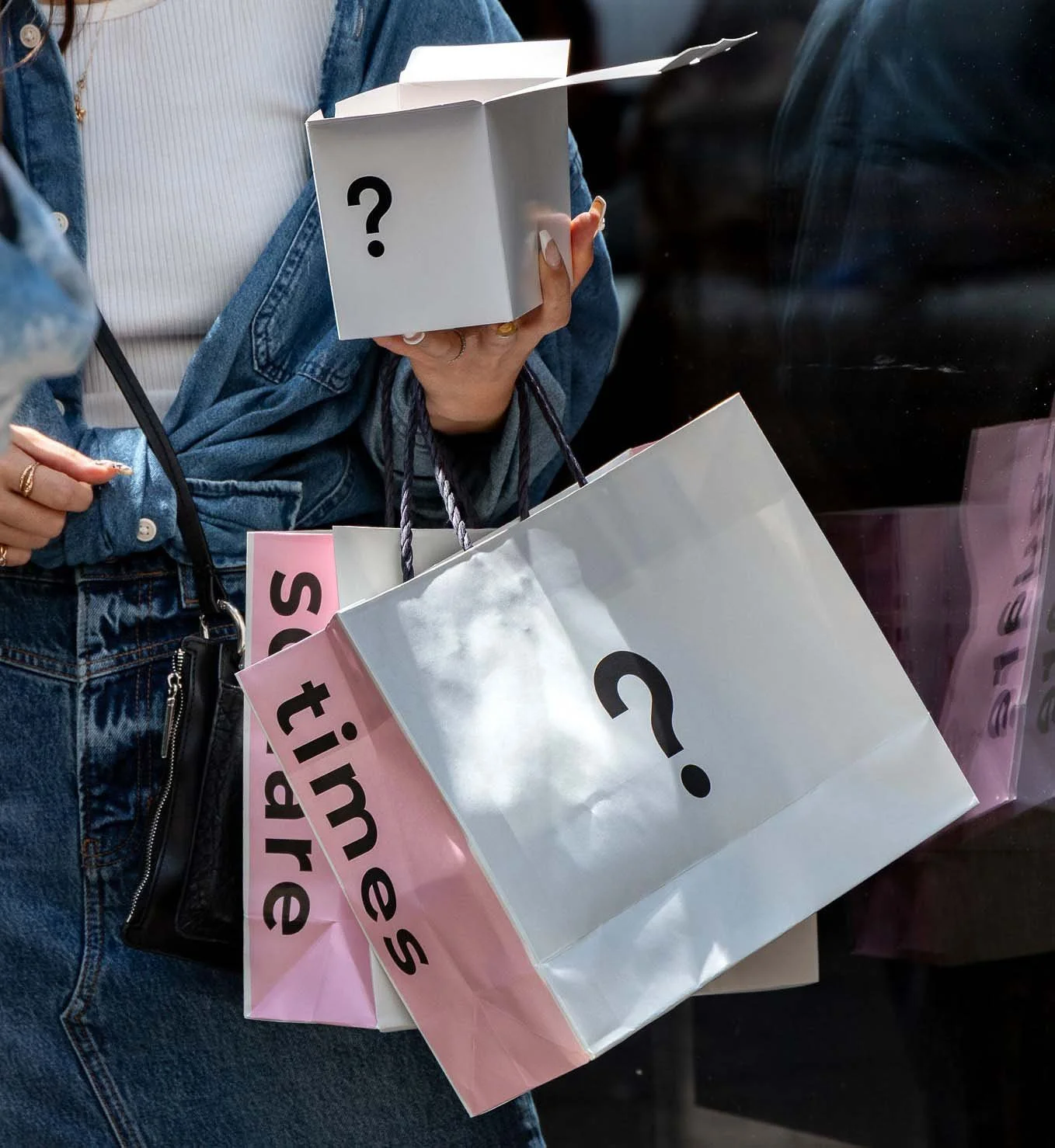 Person holding I'm donut ? bags and box