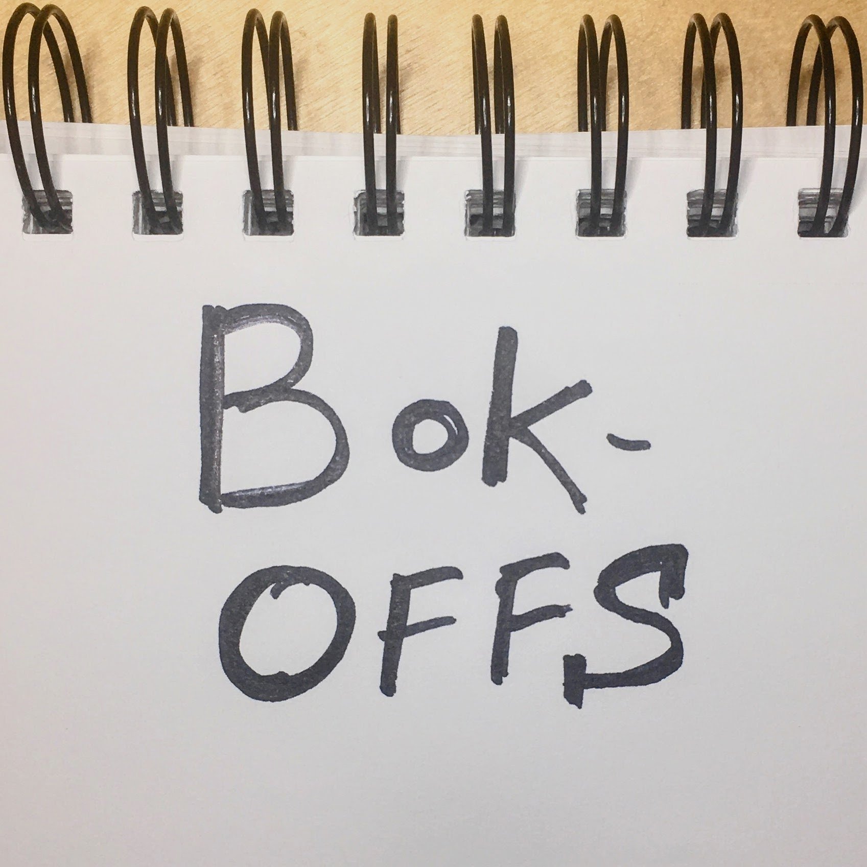 Sharpie text on a spiral bound notebook that reads Bok-offs