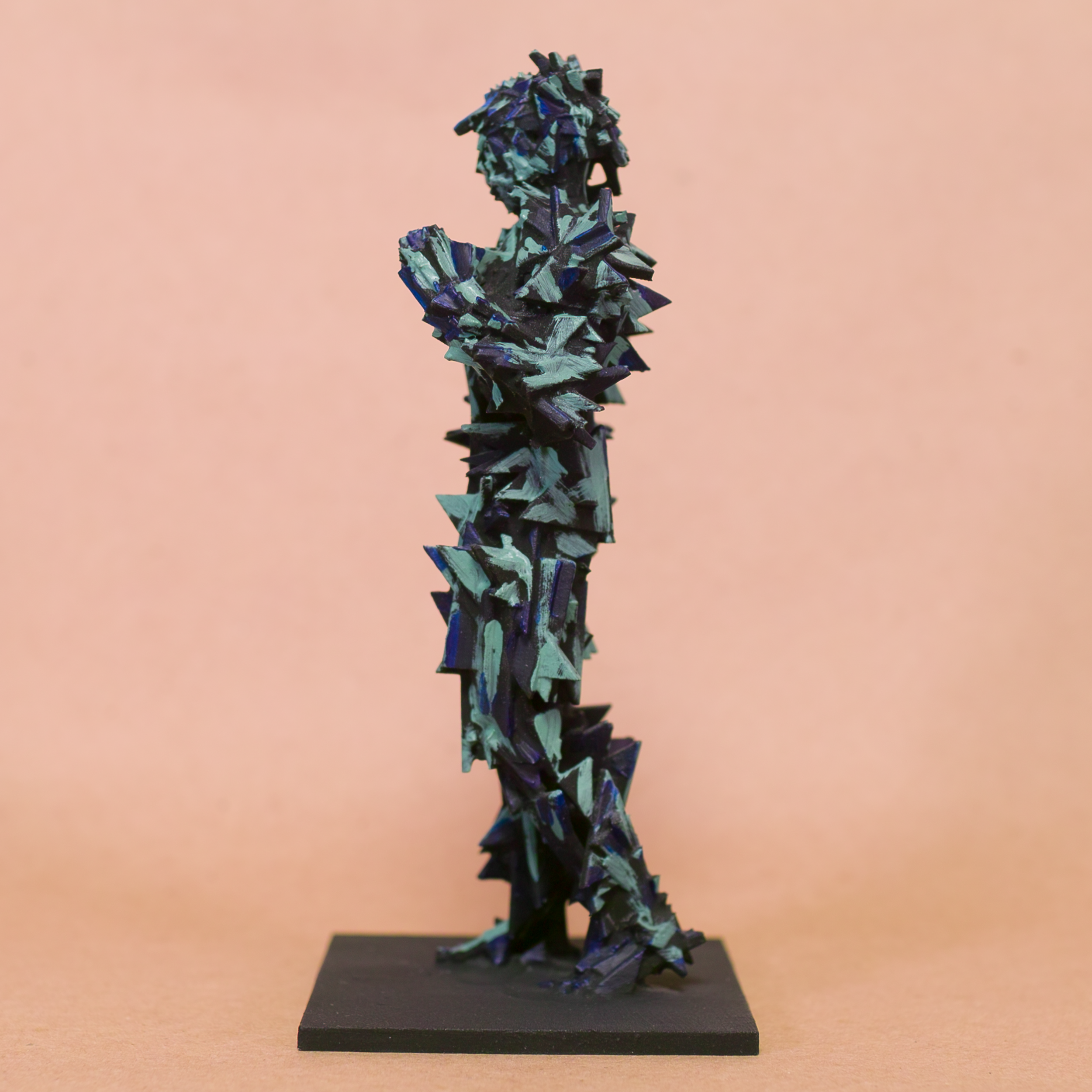 Contrapposto Doryphoros sculpture reimagined: fragmented jagged shard armor in black with iridescent blue-teal glints, brooding sentinel on black base by Mark G. Taber