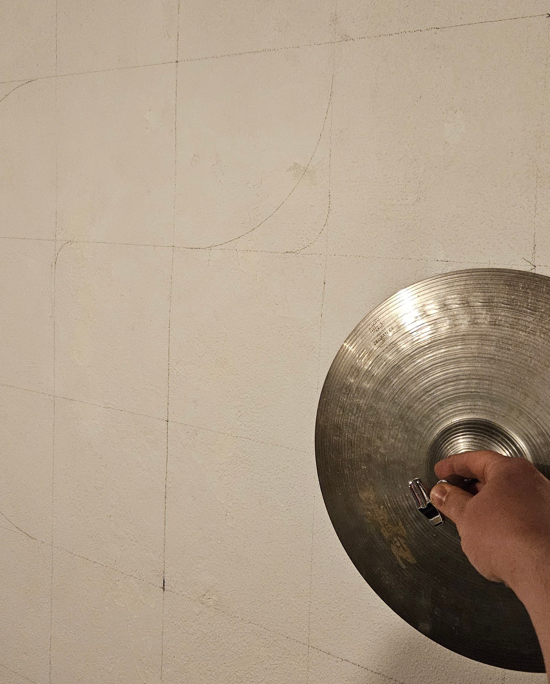 Marked out the grid on the wall and used some handy objects to draw the curves. Eventually settled on a hi-hat cymbal and an air hockey puck.