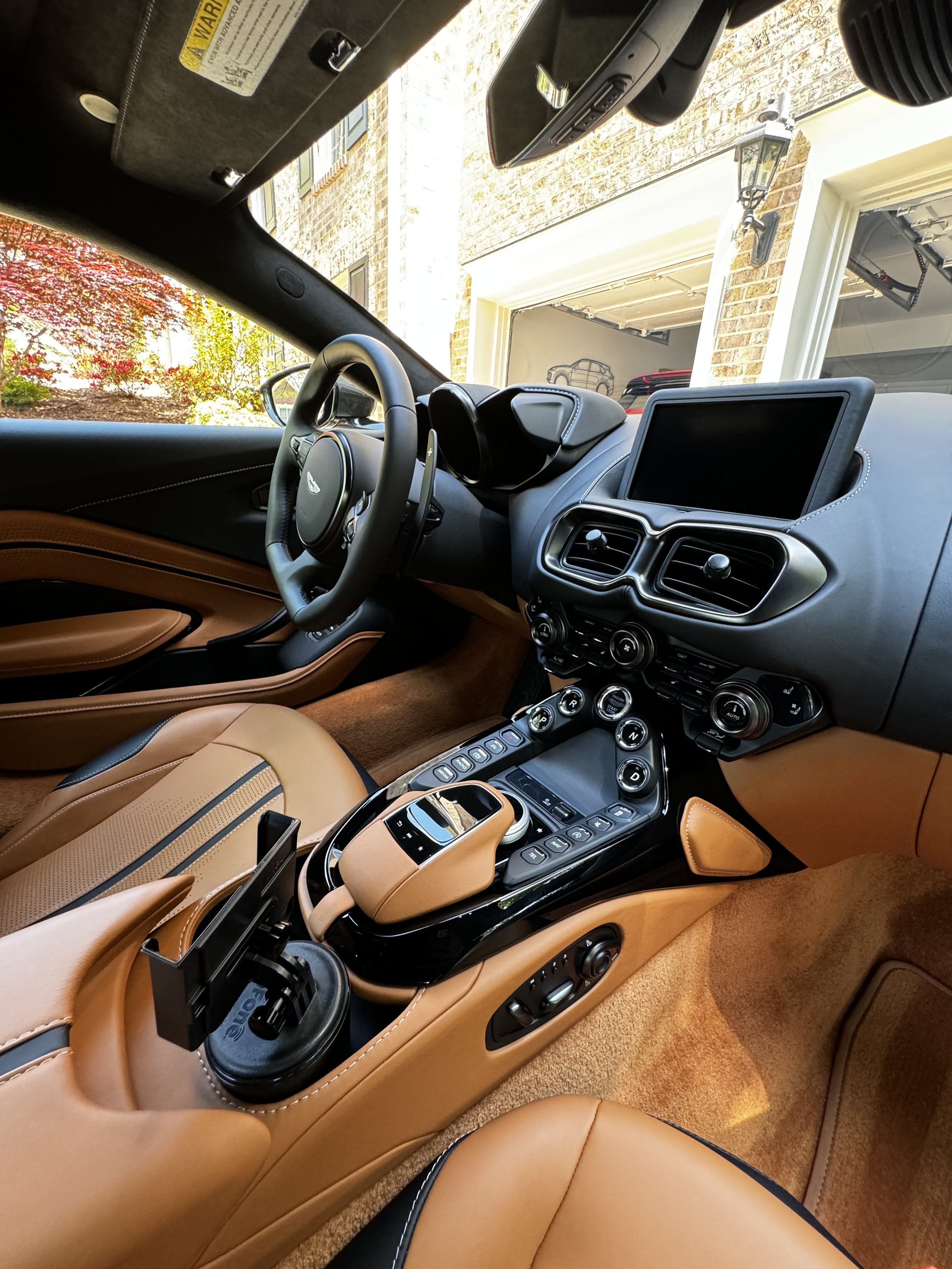 Interior of a luxury sports car showcasing leather seats, a sleek dashboard, a digital display, and various controls.