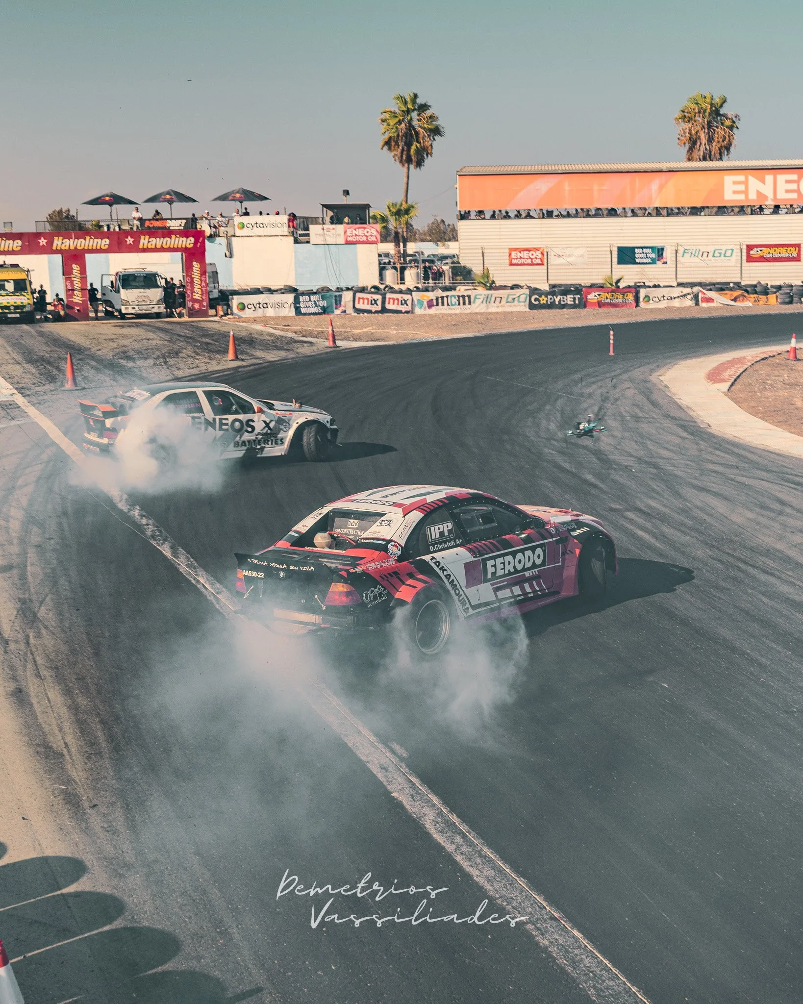 Three drift cars tandem battling around a wide turn at Achna Speedway.