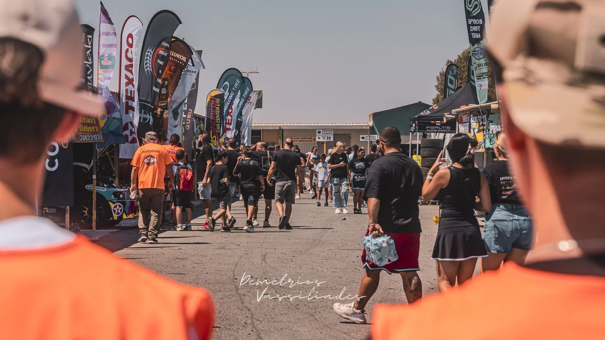 Crowd entering the paddock area at Cyprus Drift Championship Finals with flags and banners.