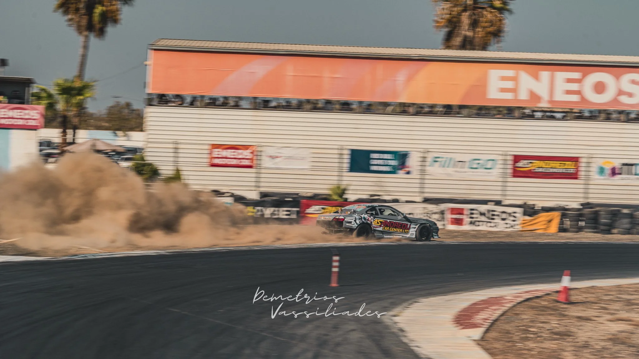 Two drift cars sliding side by side around a bend at Achna Speedway.
