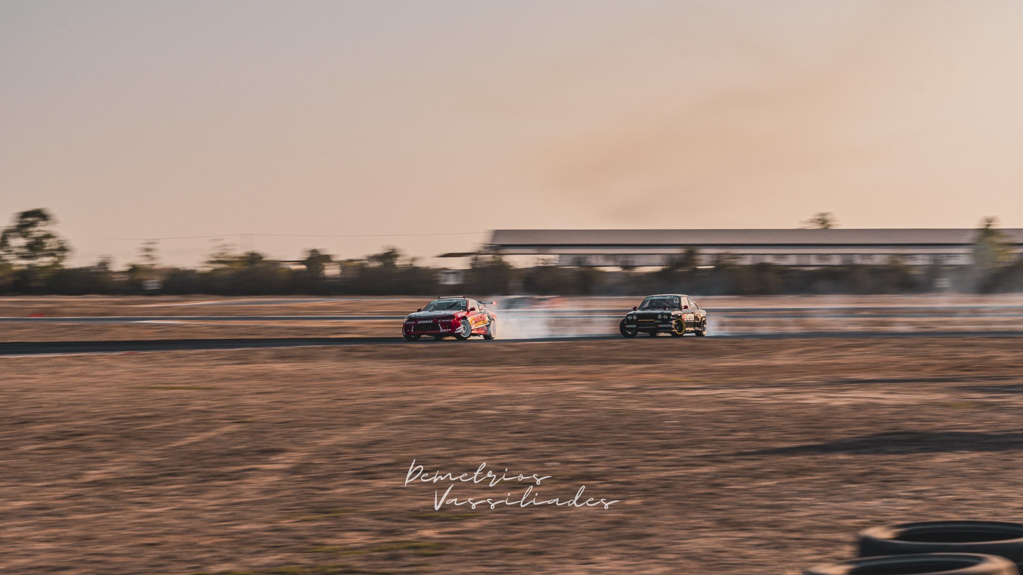 Multiple drift cars sliding across the track during a tandem battle.