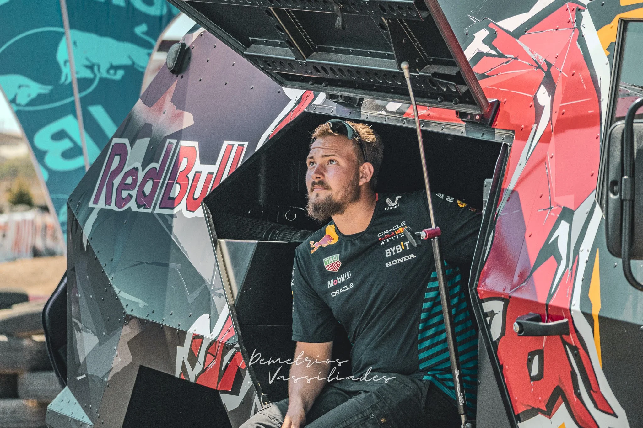 Drift driver wearing Red Bull racing gear preparing in the paddock.