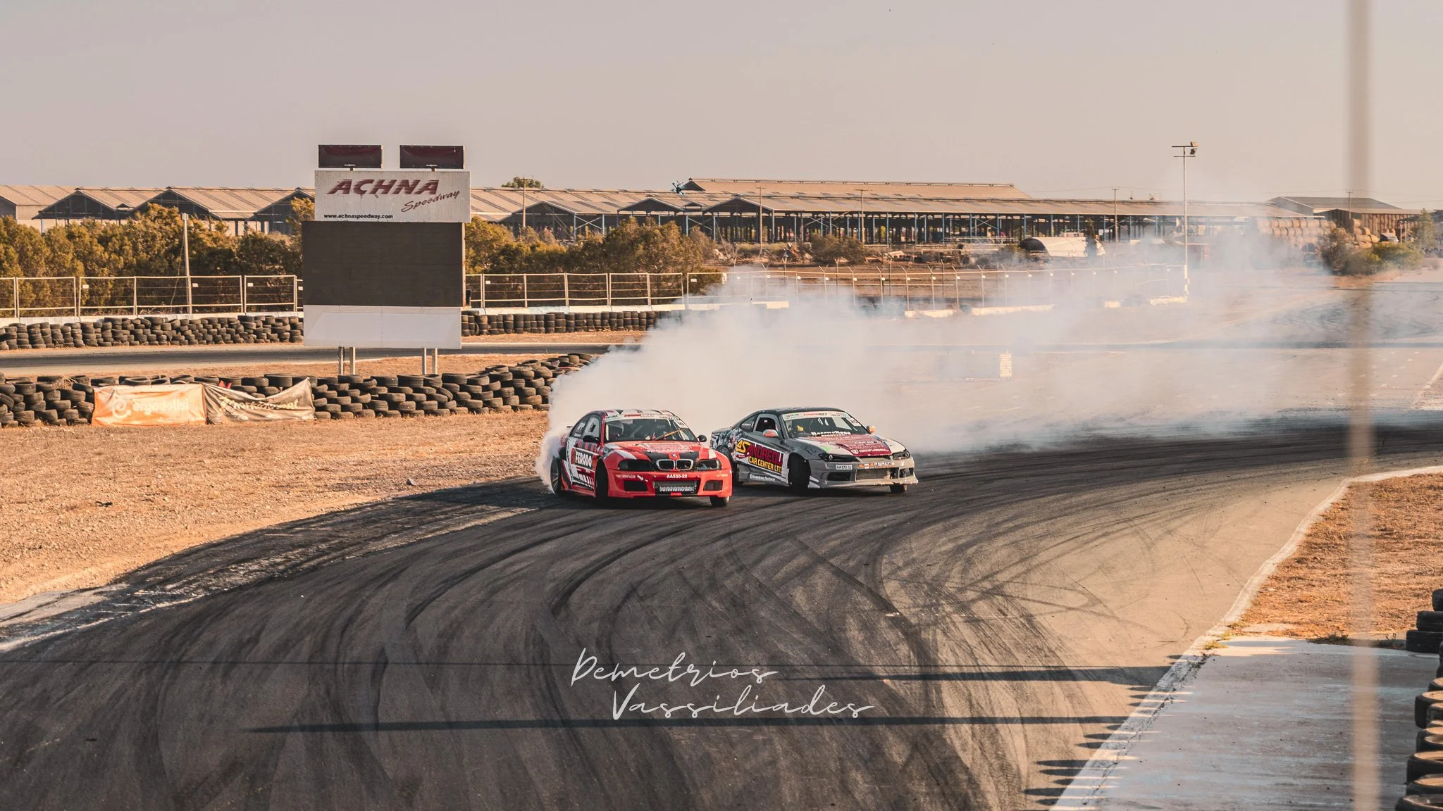 Two drift cars tandem drifting closely around a bend at Achna Speedway.