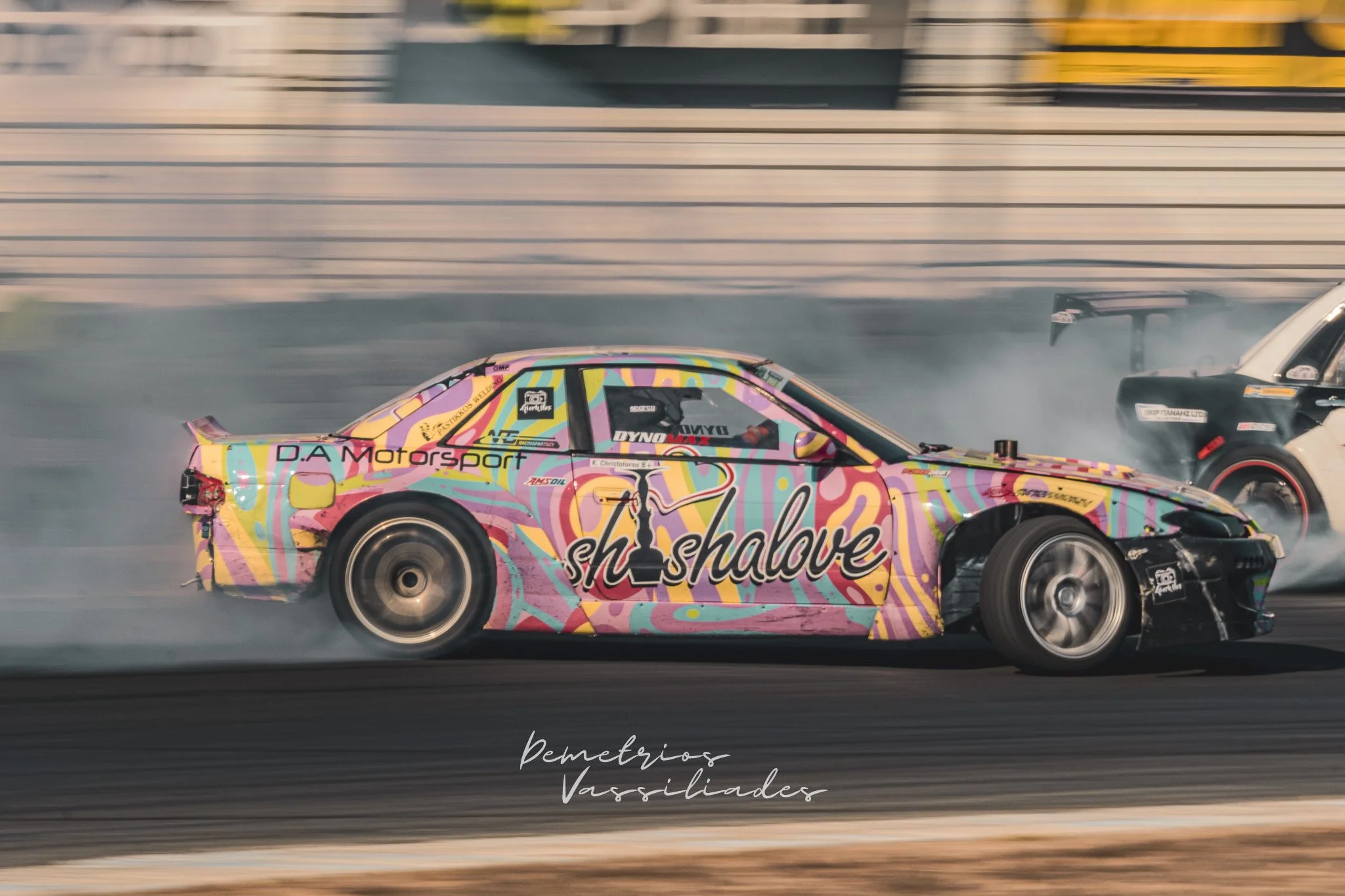 Colorful drift car with pastel graffiti-style livery sliding at high speed.