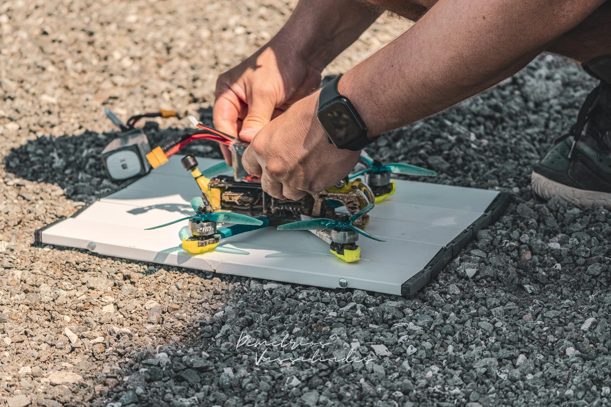 Hands working on a FPV Drone on a white board at the event.