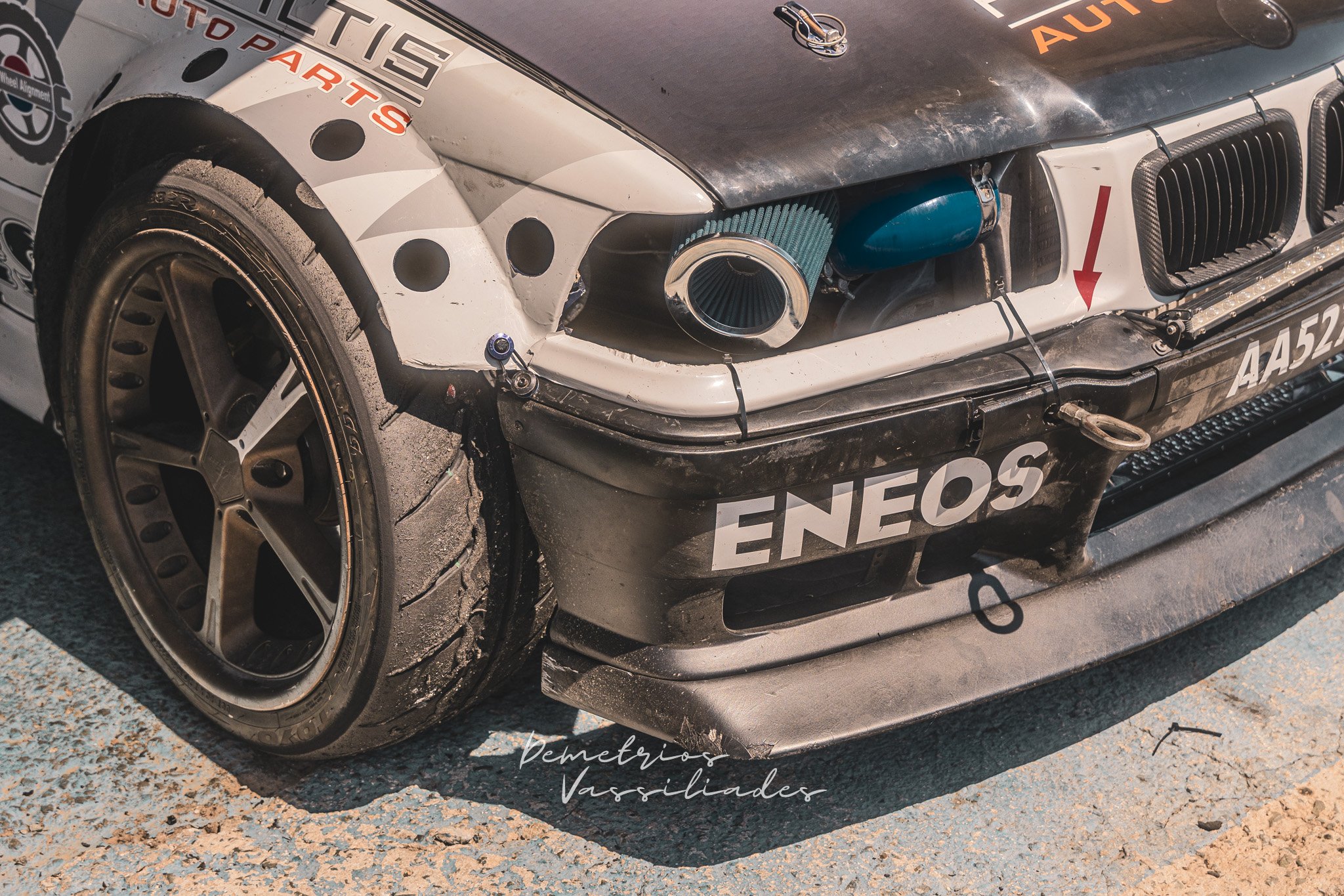 Close-up of a drift car front bumper with ENEOS sponsor decal.