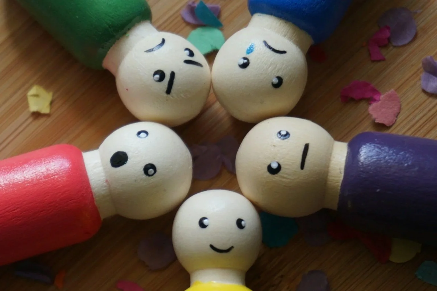 Wooden dolls with faces shoping different emotions