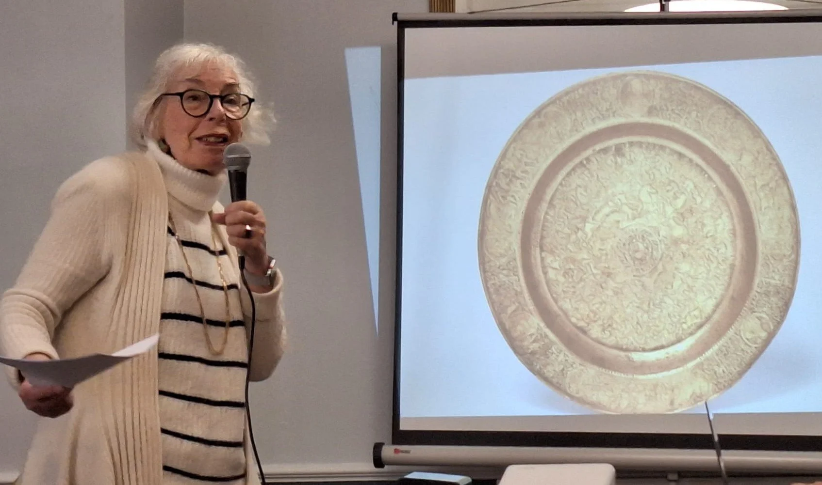 Photo of lady with glasses holding a microphone