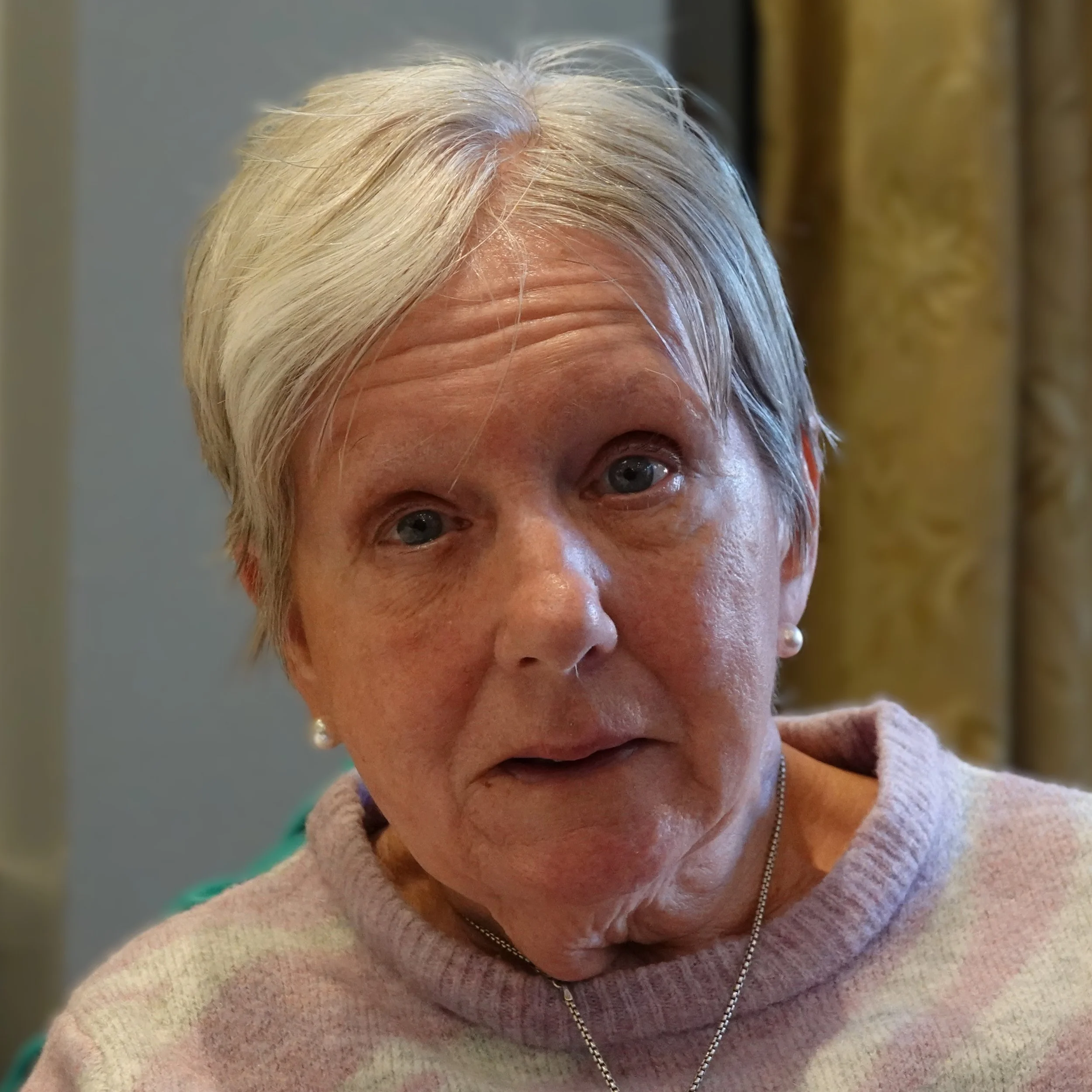 Close-up of a woman with short gray hair at a Speakability meeting in Newbury