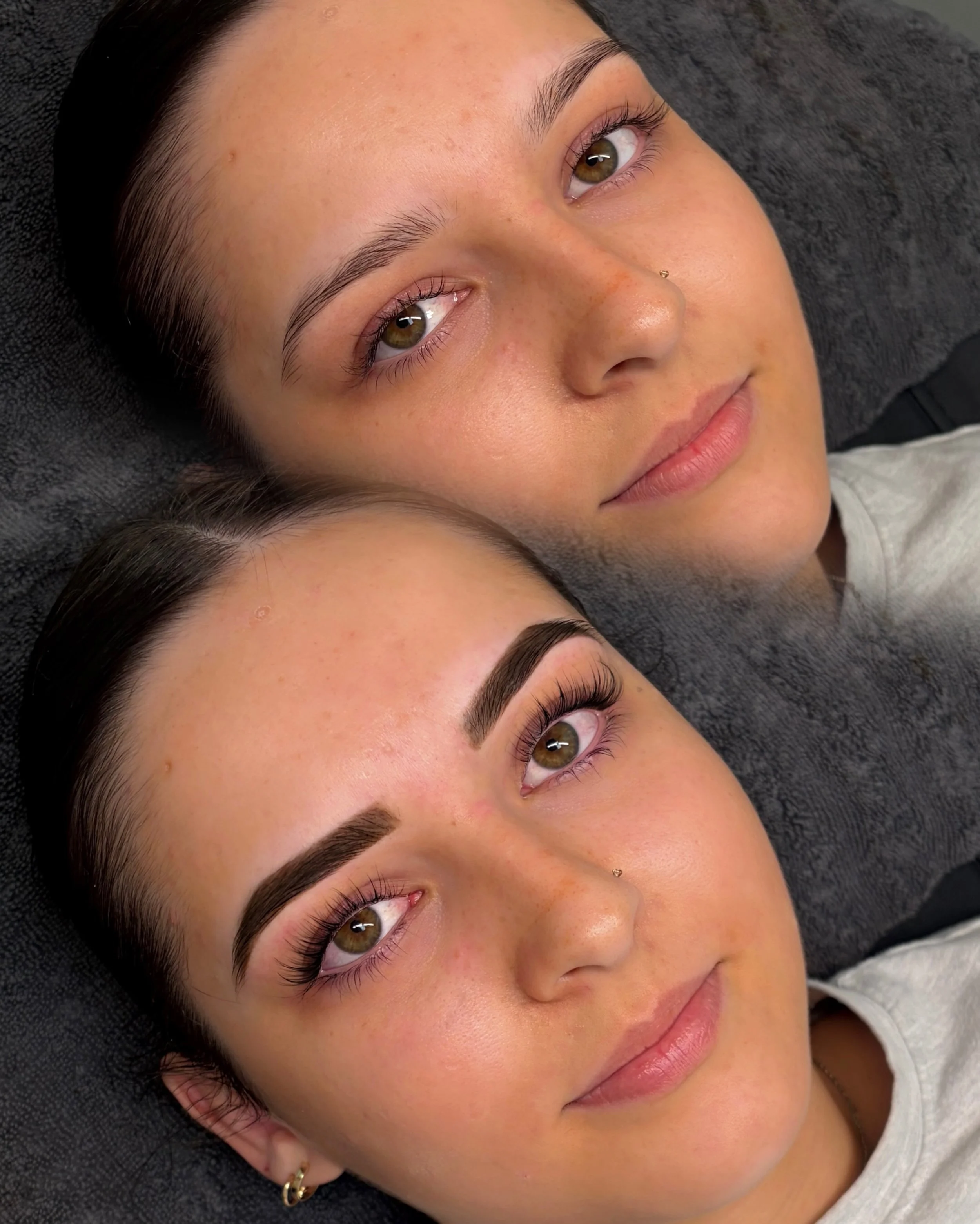 Close-up of two women lying down with their heads touching, showing their faces and eyes.