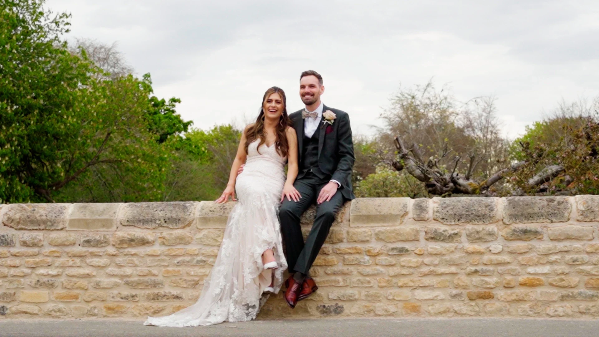 Wedding couple sat on a wall