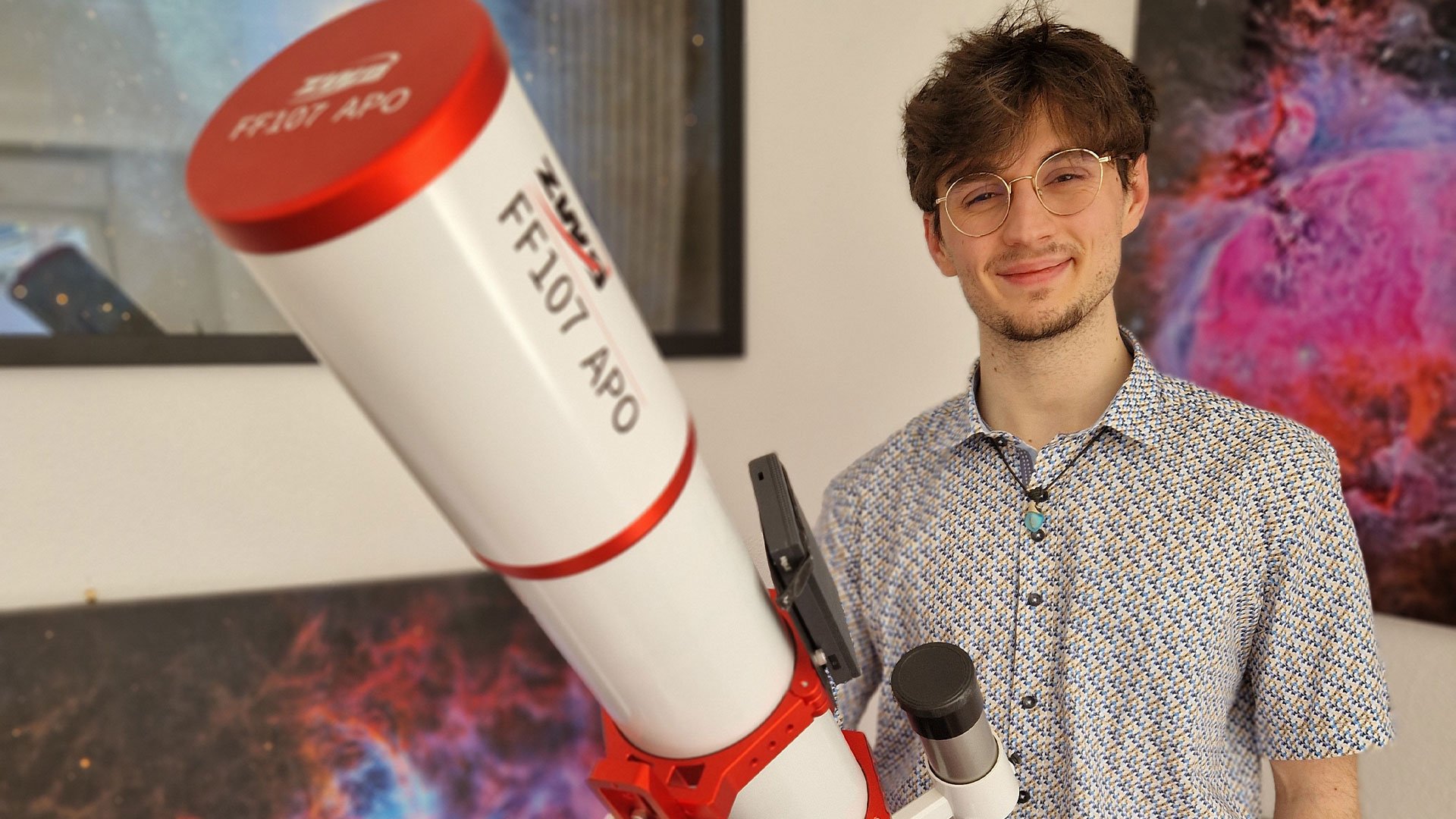 Léo Habig souriant portant une chemise à motif, tenant un télescope nommé 'FF107 Apo' côté d'une galerie d'astrophotographies du ciel profond.