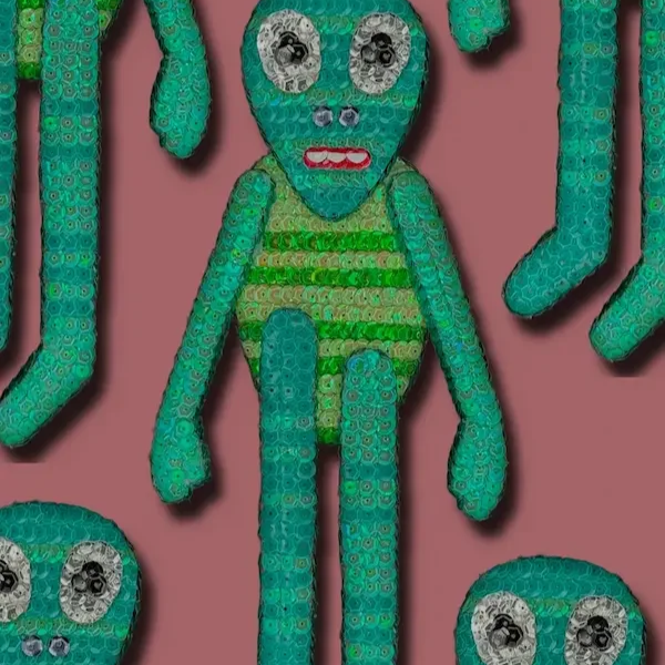 A sequined plush toy resembling an alien with large eyes, a small nose, red lips, and a striped body, surrounded by other similar toys against a pink background.