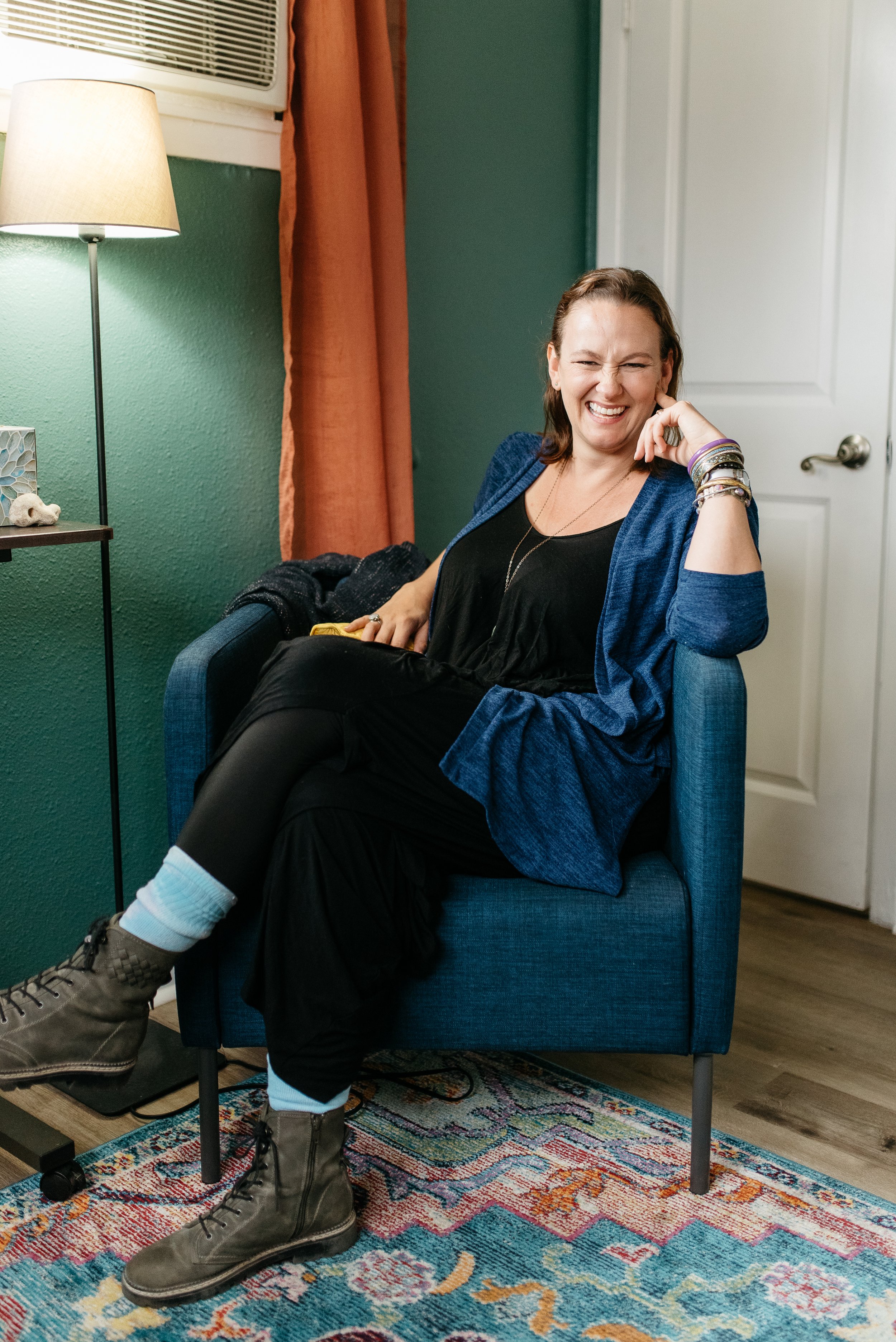 woman sits in her chair looking happy and smiling