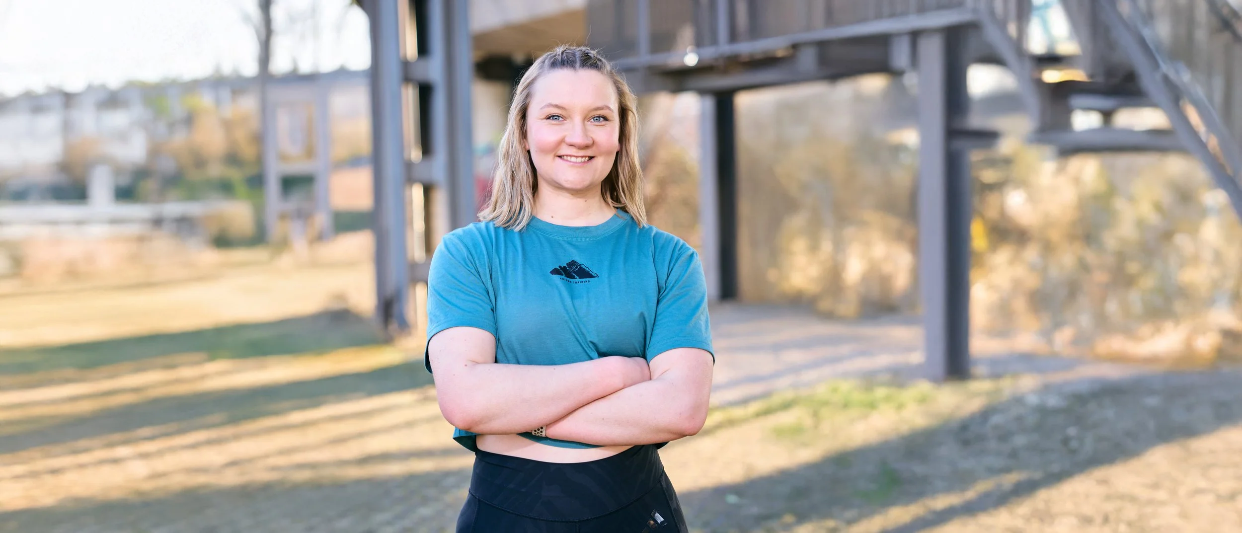 Katharina Aschmetat, Personal Trainerin in Nürnberg, mit verschränkten Armen im Freien