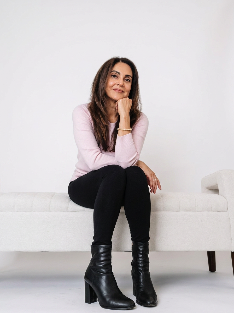 Arzeen Asaria, mindset coach for women, seated on a white bench