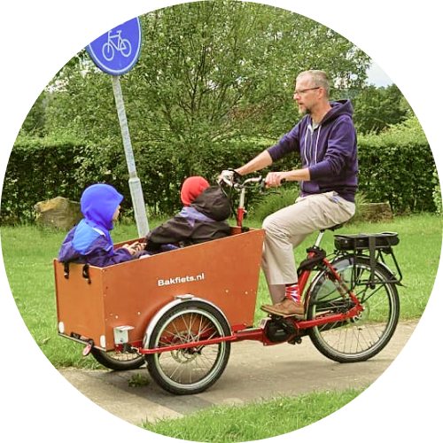 Thom van der Doef riding a cargo bike with his twin boys in the Netherlands