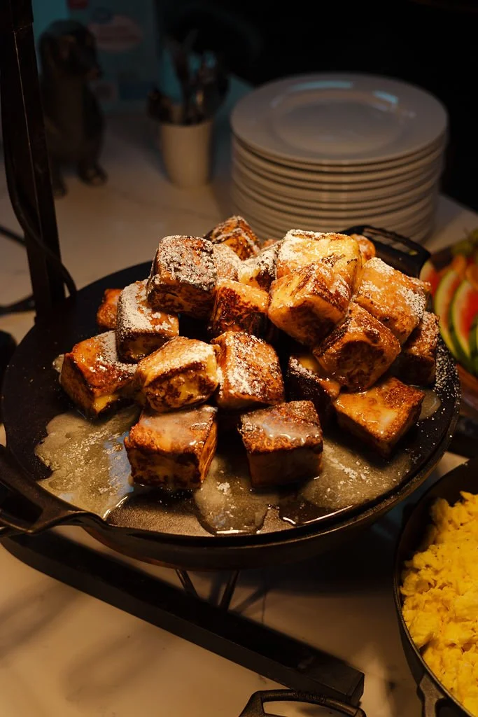 Piles of fried plantains dusted with powdered sugar on a serving tray.