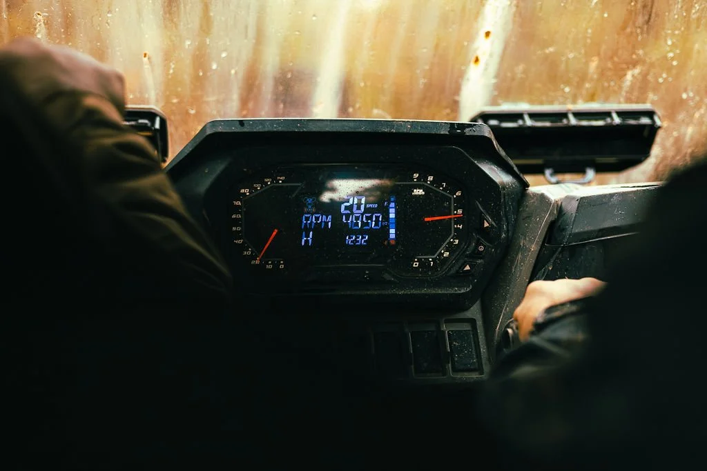 Dashboard of a vehicle showing speed, RPM, and other metrics with a blurry view through the windshield.