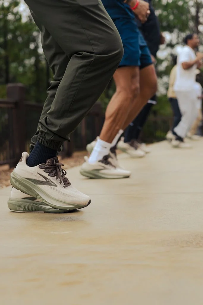 People practicing double Dutch jump rope outdoors on a wooden pathway.