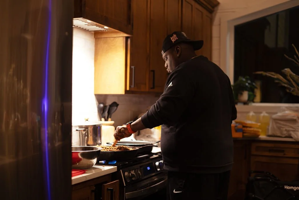A man cooking dinner in a kitchen at night.