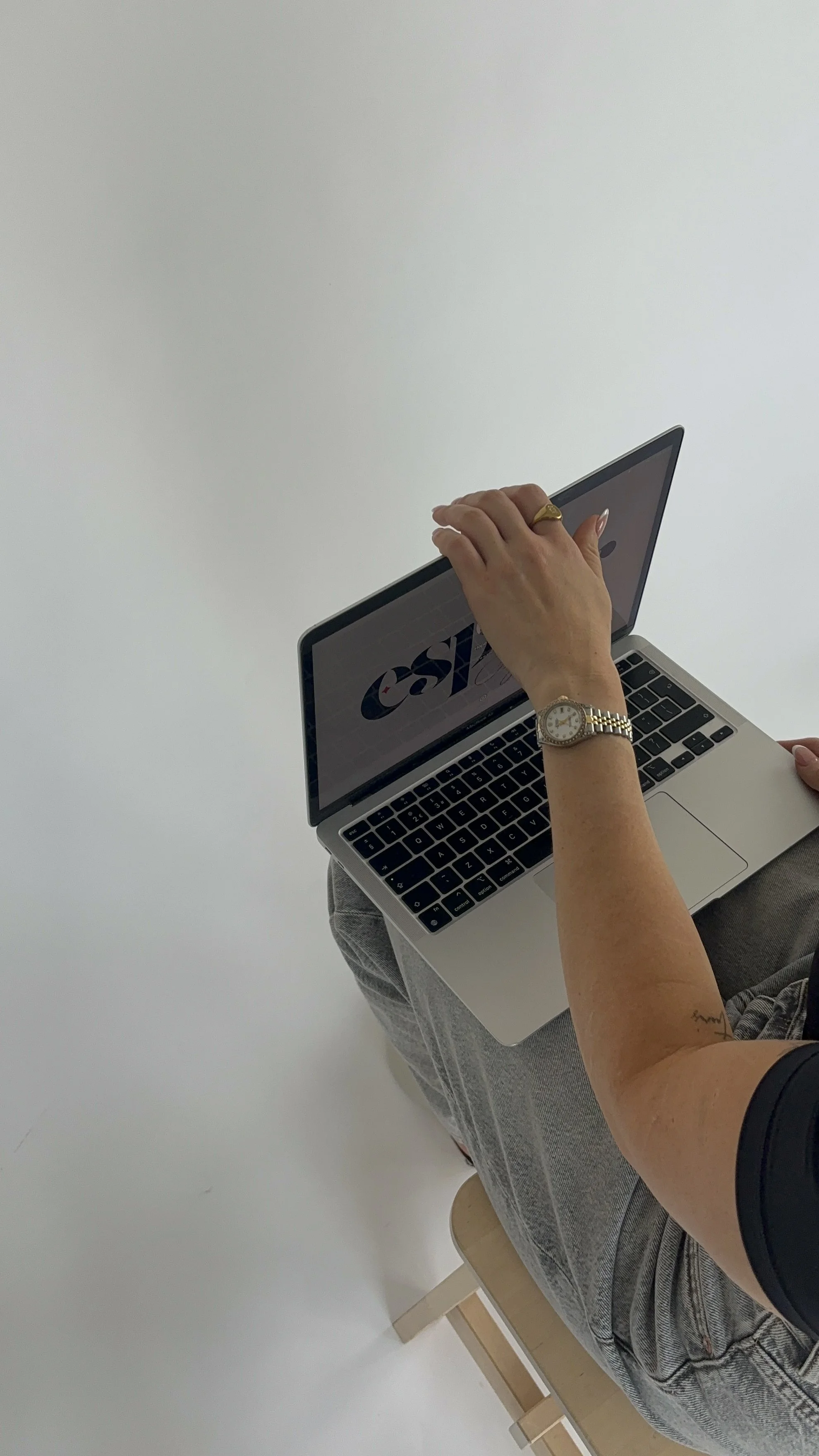 A person holds a laptop displaying the NASA logo on a plain white background.