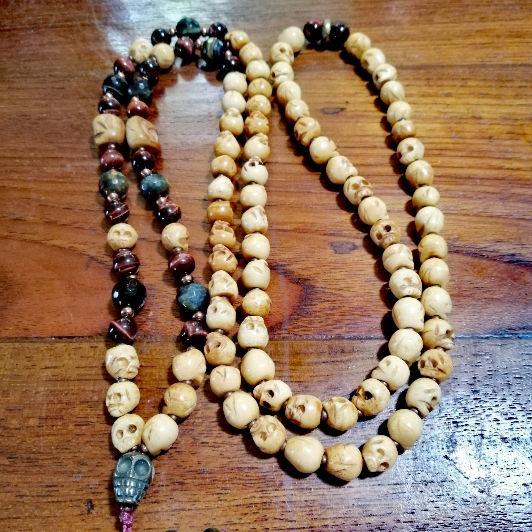 Carved Bone Skulls with Red and Blue Tiger's Eye Mala