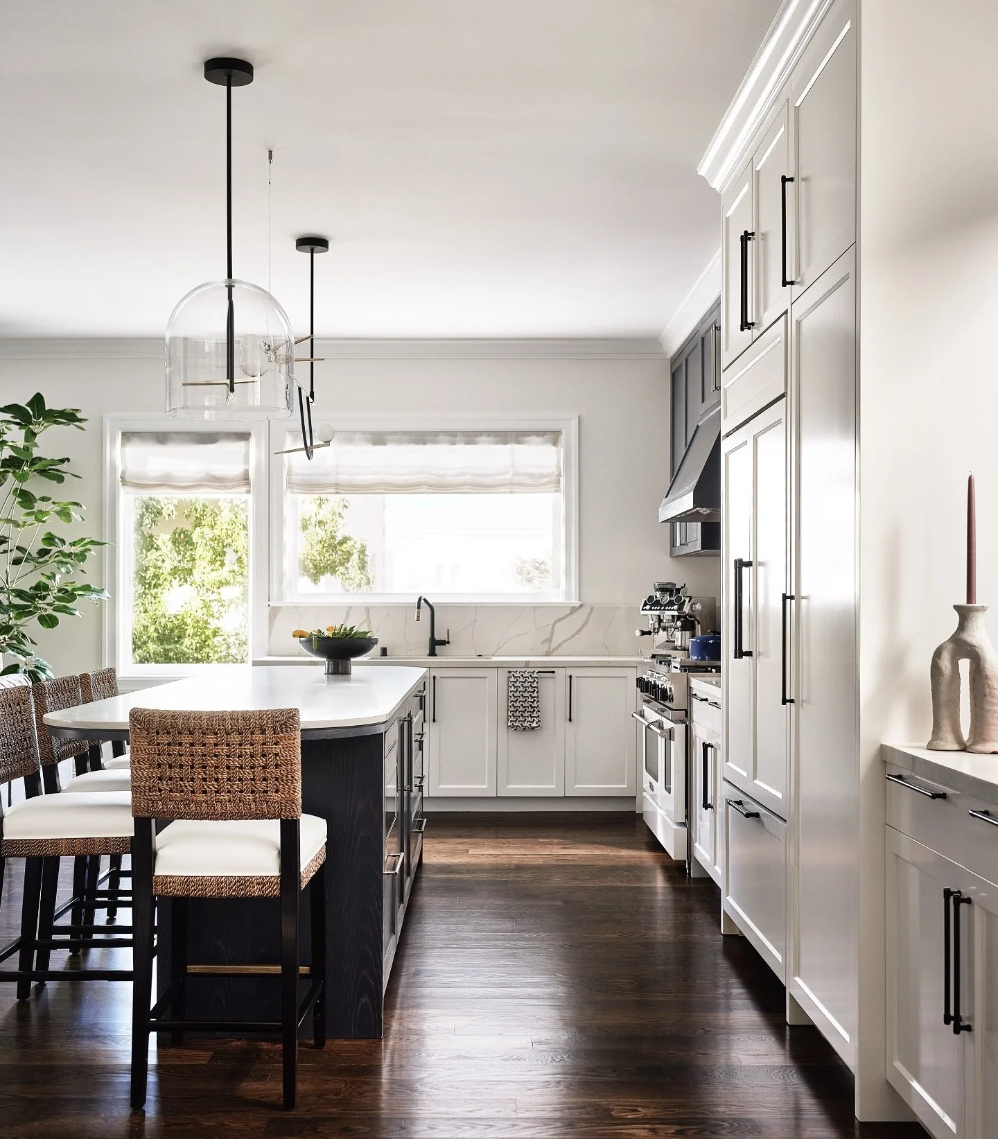 This kitchen nails, the &ldquo;casual luxury&rdquo; thing. 

Crisp white cabinets, rich wood floors, and woven textures keep it feeling fresh, timeless, and relaxed. It&rsquo;s the kind of space that says, come on in, stay a while, and pour a glass o