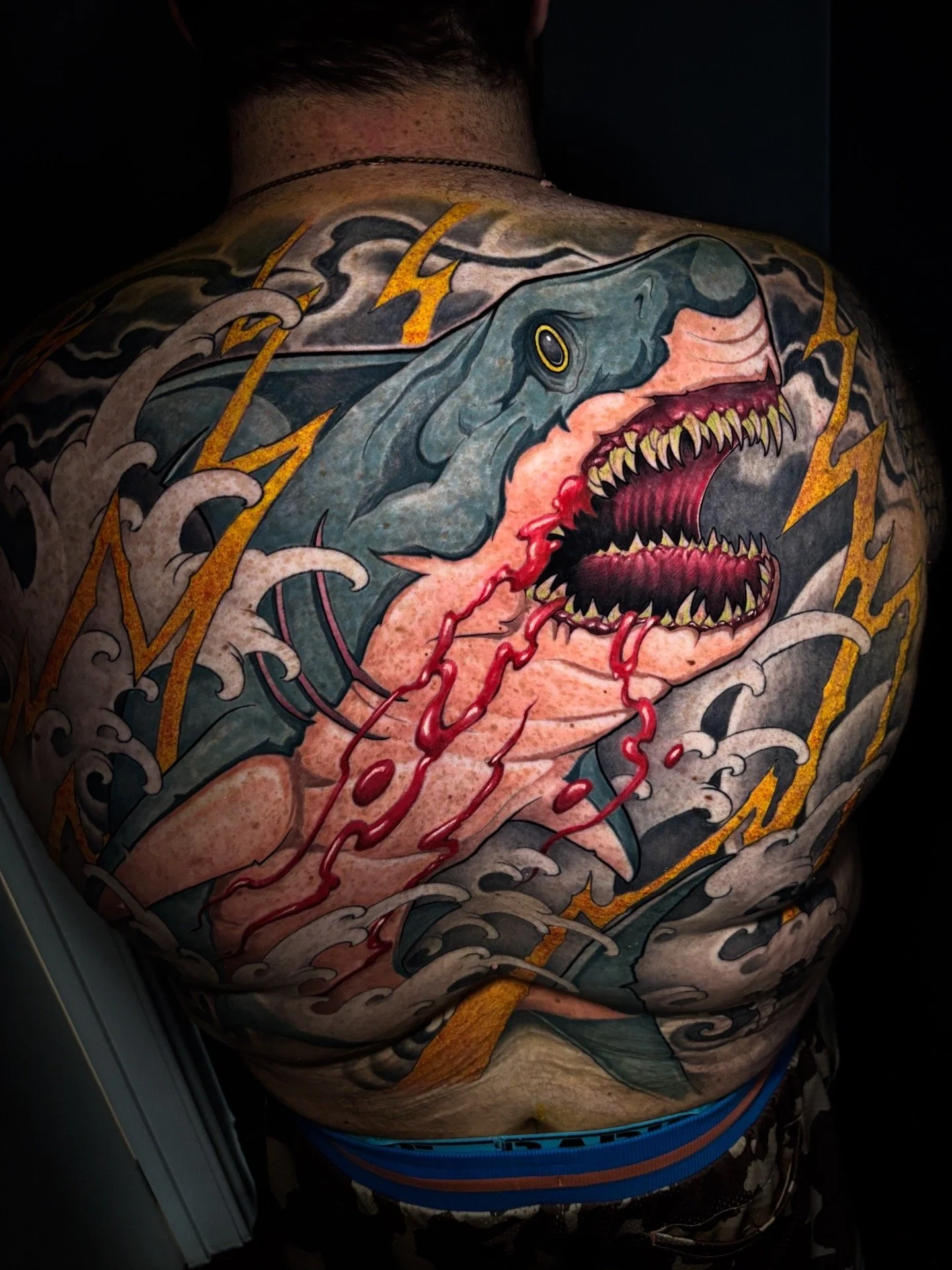 Shark backpiece with Japanese-inspired waves and yellow lightning by Nicklas Wong, tattoo artist in Northcote, Melbourne