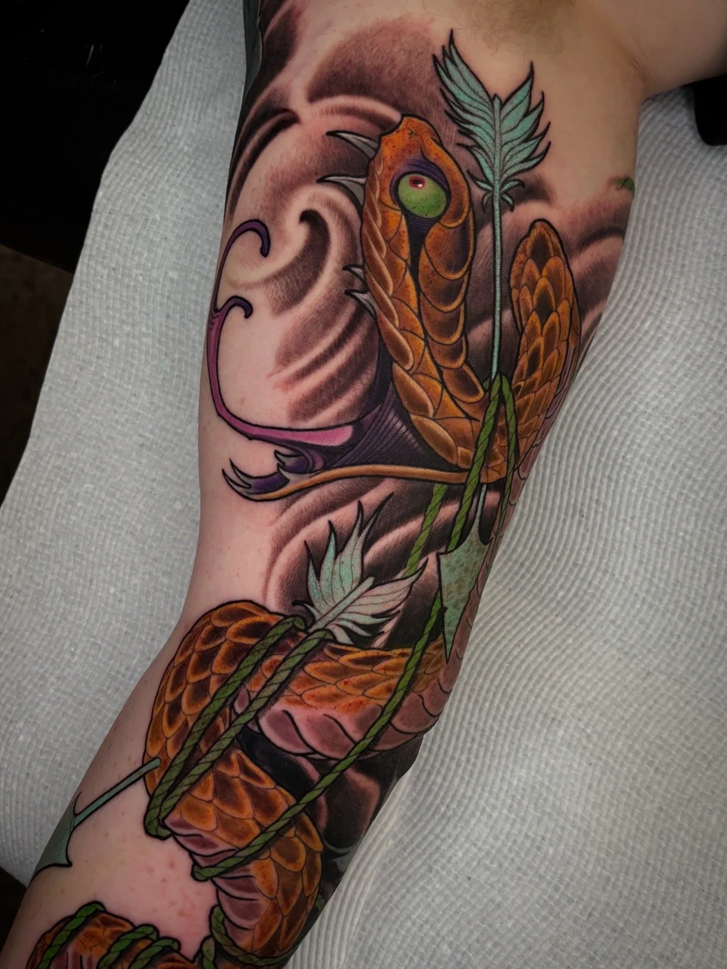 Japanese-inspired snake tattoo winding through leaves and clouds by Nicklas Wong, tattoo artist in Northcote, Melbourne