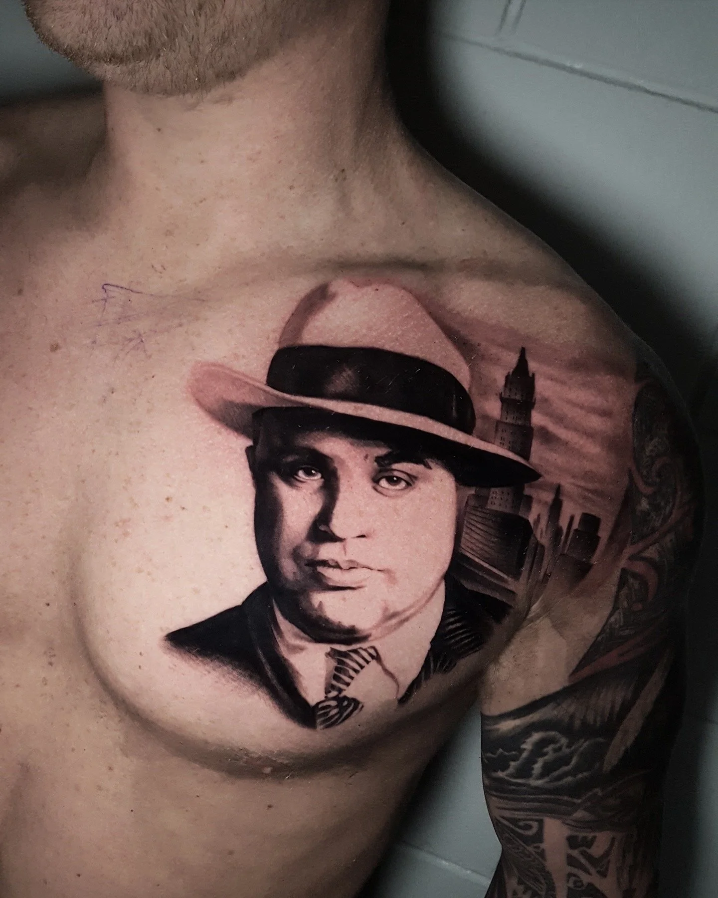 Black and grey chest portrait tattoo of a man wearing a hat by Nicklas Wong, tattoo artist in Northcote, Melbourne