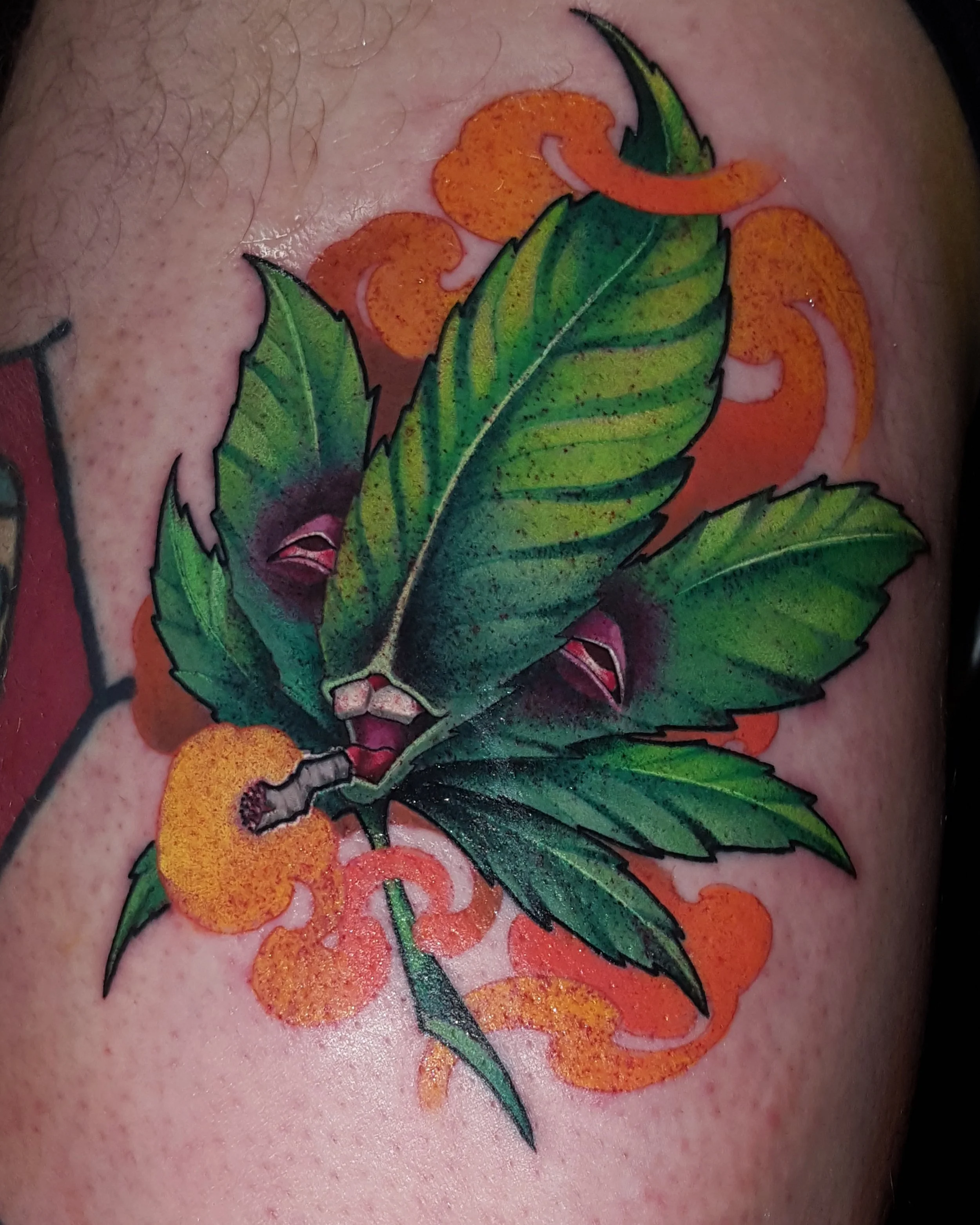 Green leaf character tattoo with orange smoke by Nicklas Wong, tattoo artist in Northcote, Melbourne