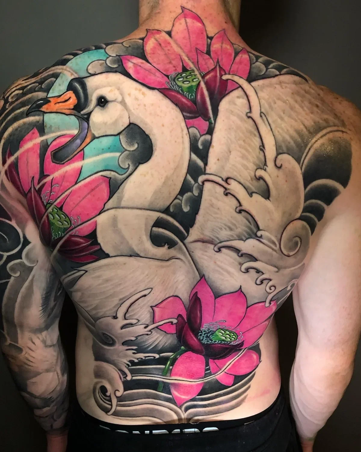 White swan and pink lotus backpiece with Japanese-style waves by Nicklas Wong, tattoo artist in Northcote, Melbourne