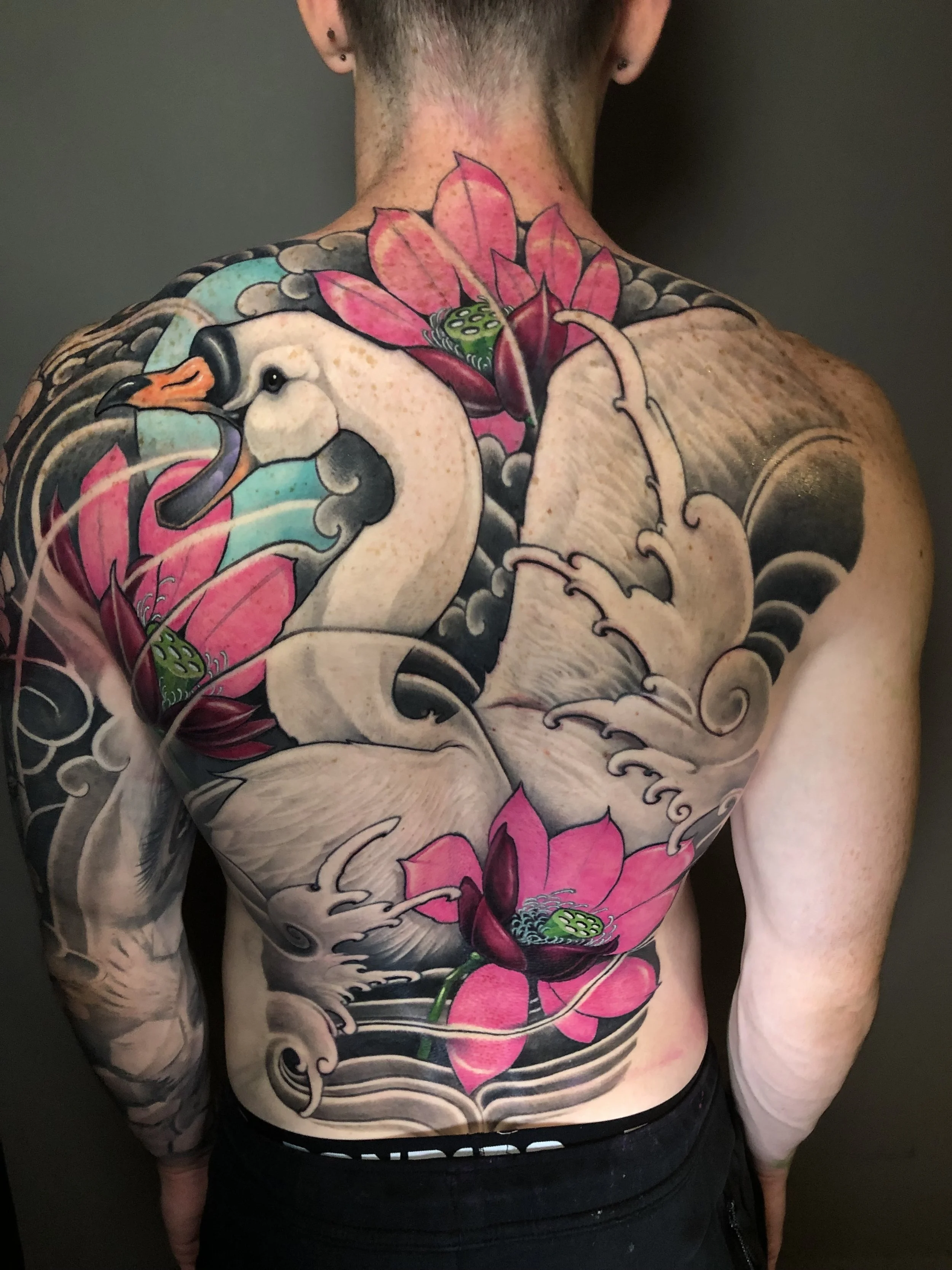 White swan and pink lotus backpiece with Japanese-style waves by Nicklas Wong, tattoo artist in Northcote, Melbourne