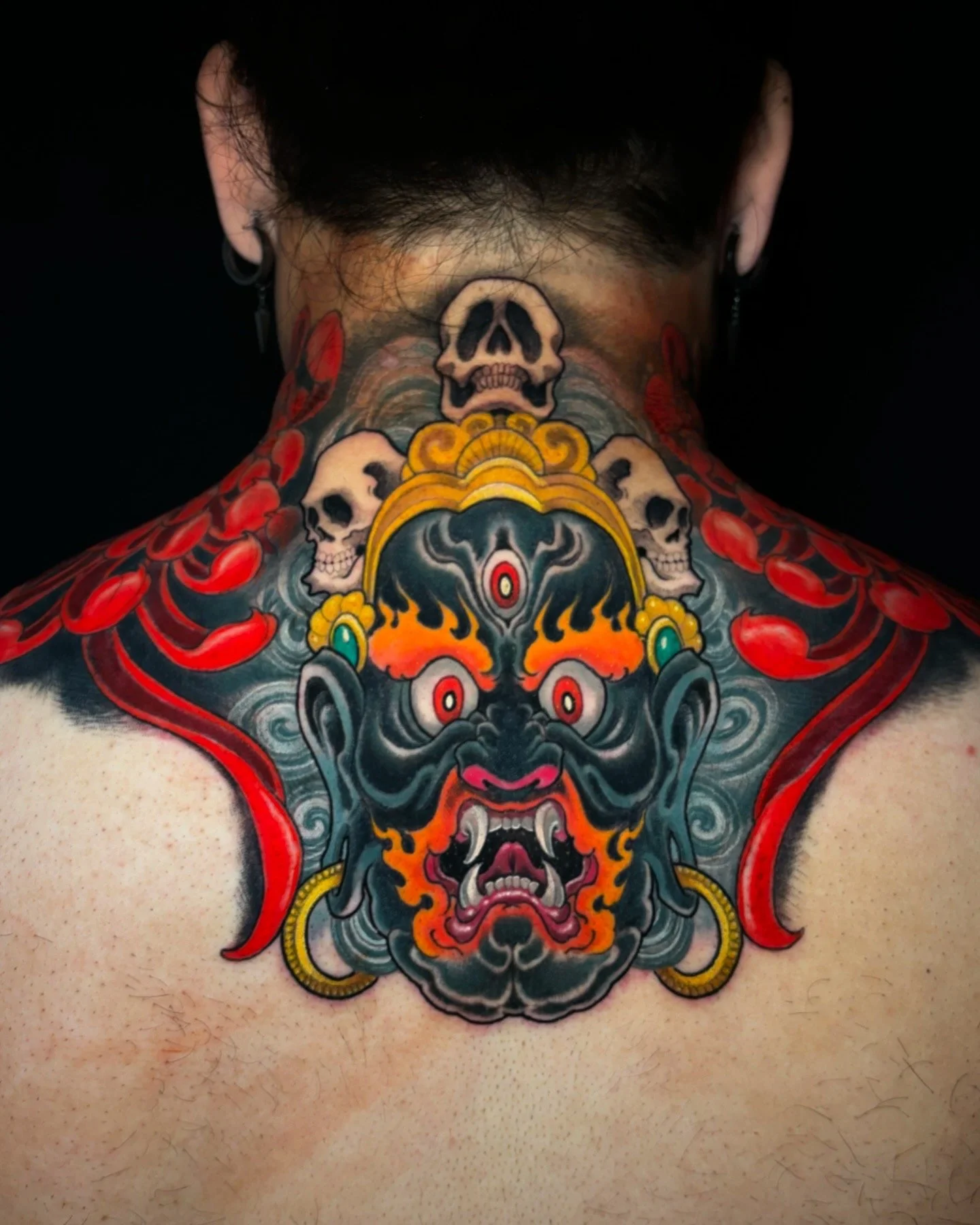 Colourful ornamental guardian mask tattoo across the back of the neck by Nicklas Wong, tattoo artist in Northcote, Melbourne