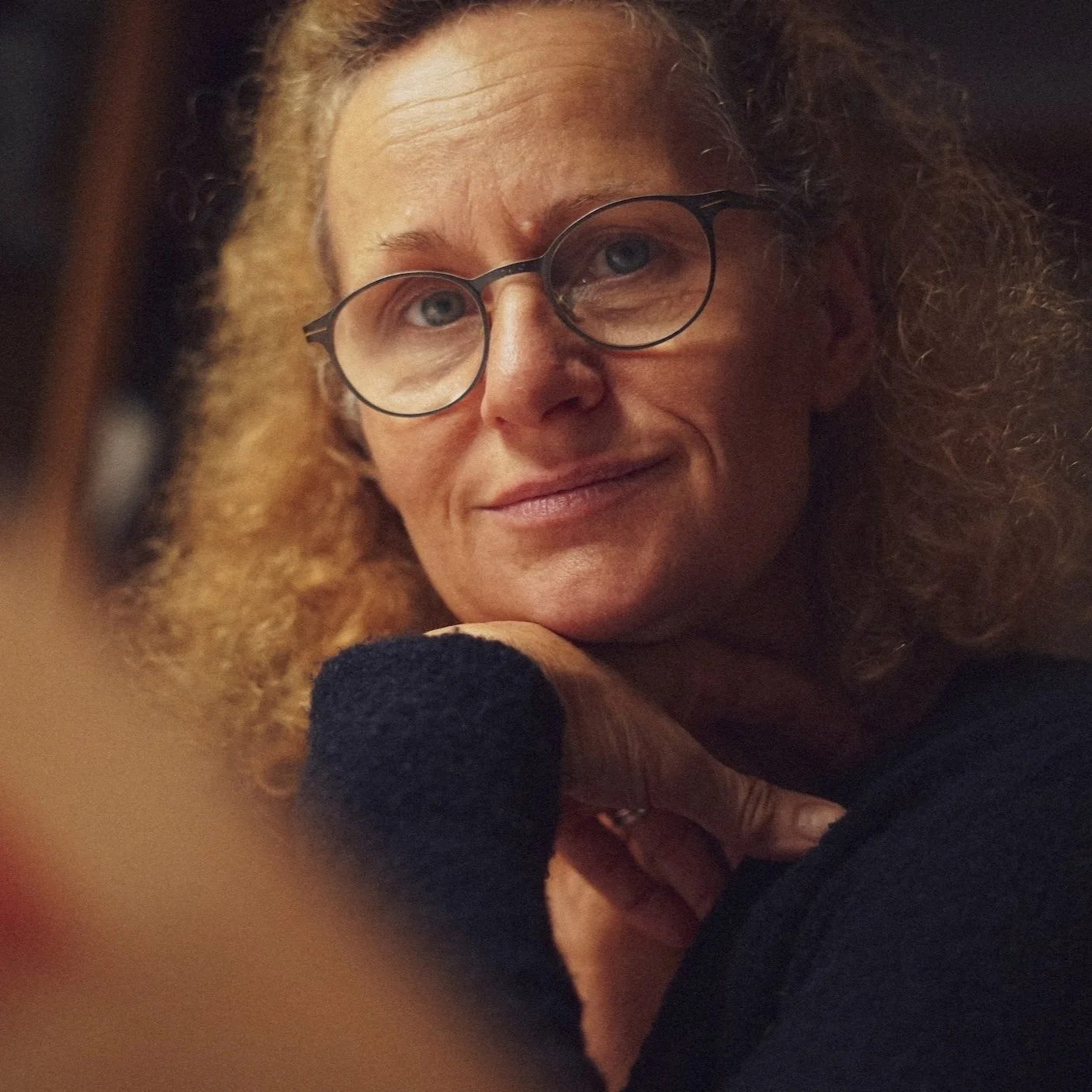 An elderly woman wearing glasses looks peaceful after sessions for spiritual therapy