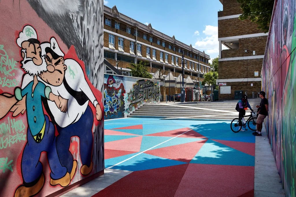 Geometric pattern of colour forms the floor of the ball court, stone Spanish steps incorporate a ramped approach from street level