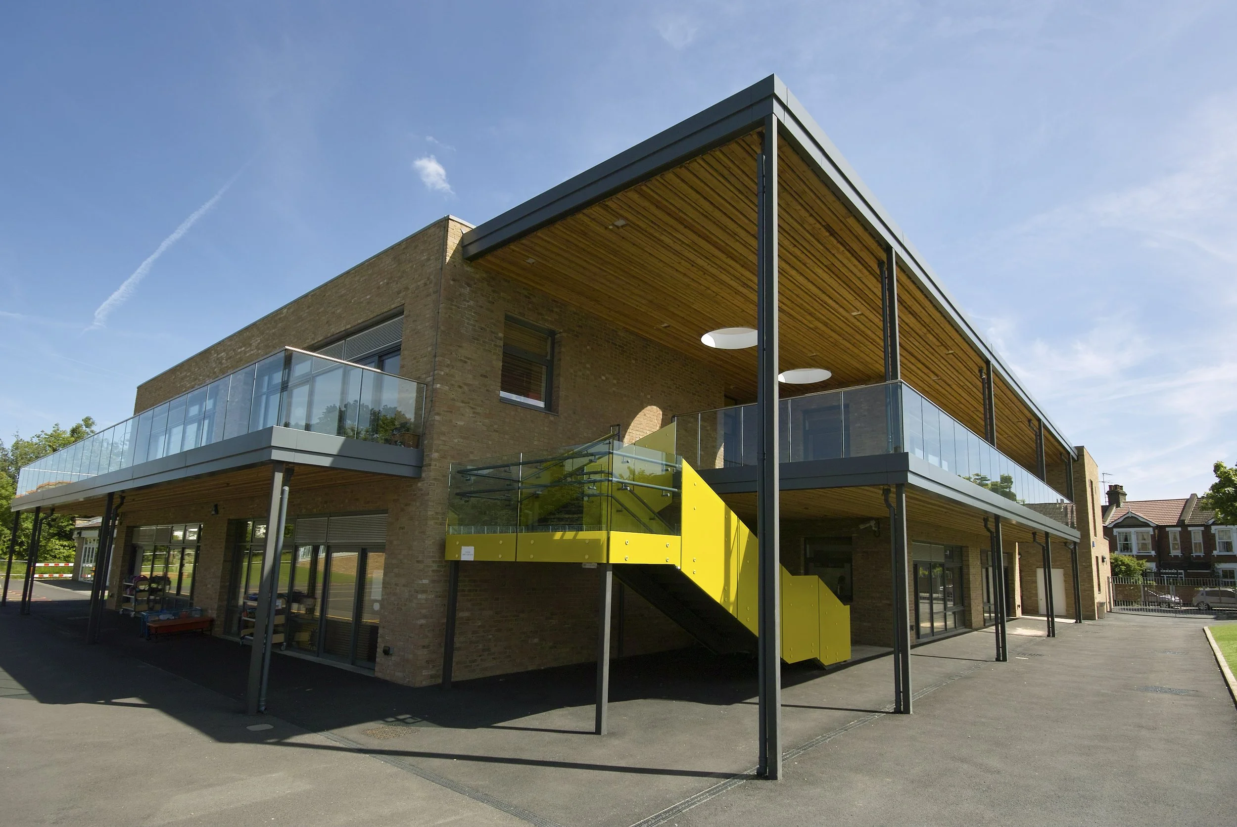 bold yellow staircase serving the upper floor deck area under a timber clad roof canopy
