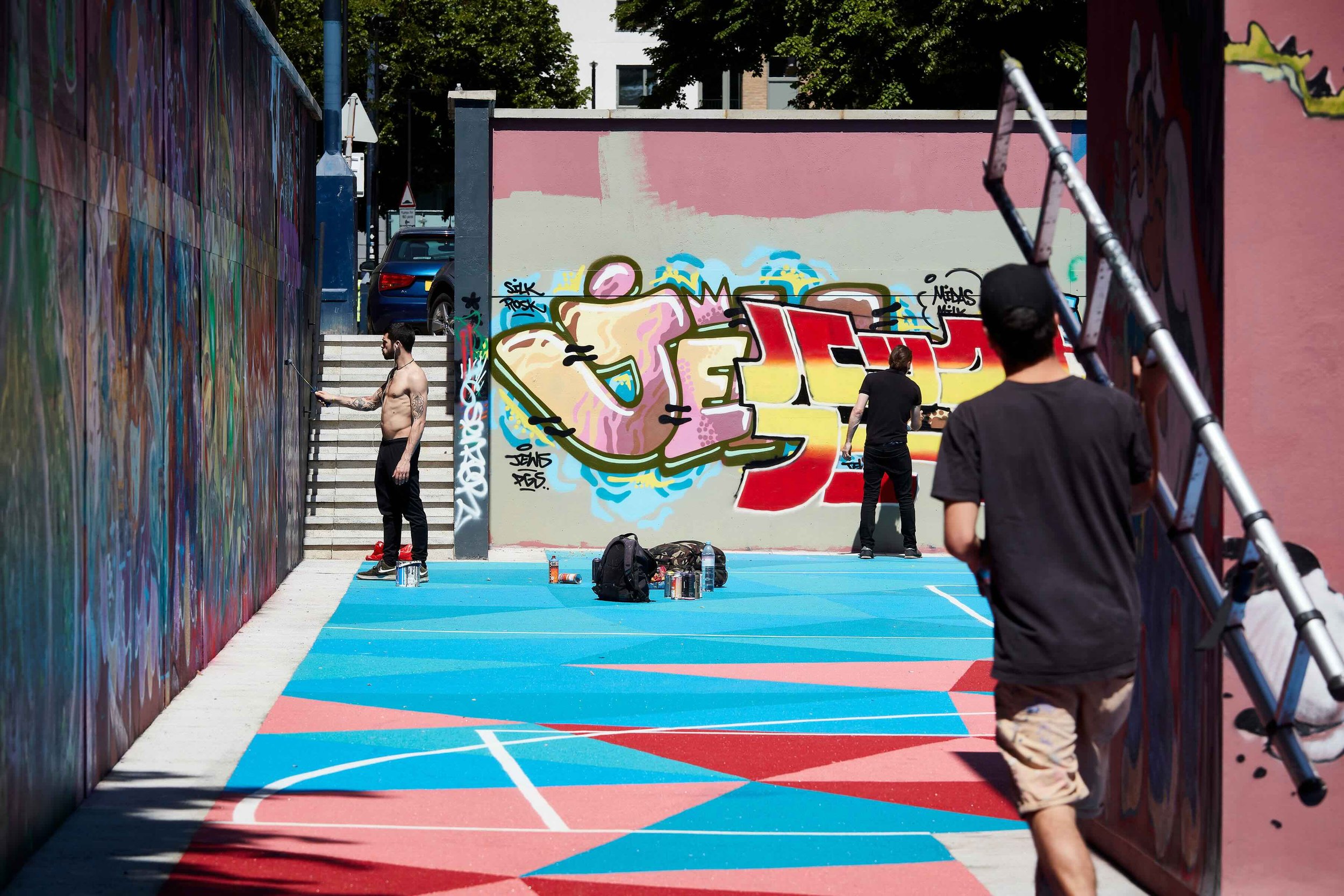 artist painting street art on the ball court walls.