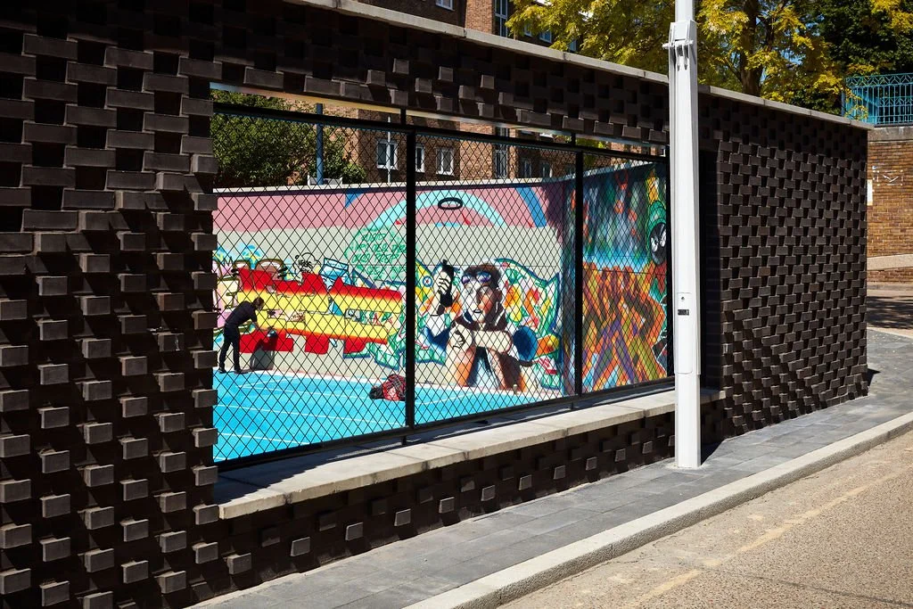 textured brick work wall with opening to allow glimpses of the art and activities within the space