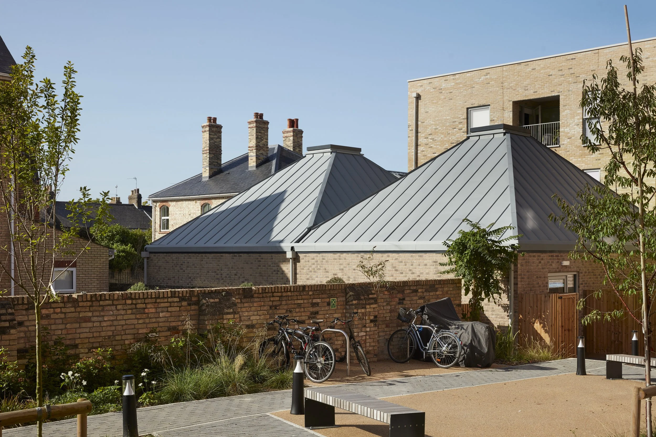 view across the community garden towards the vaulted roofs of the centre building