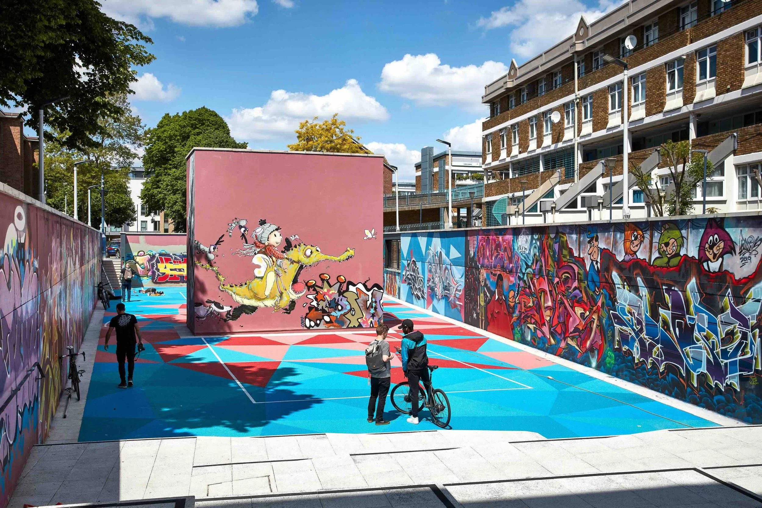 view across the ball court with graphics, street art and graffiti painted on the surrounding walls