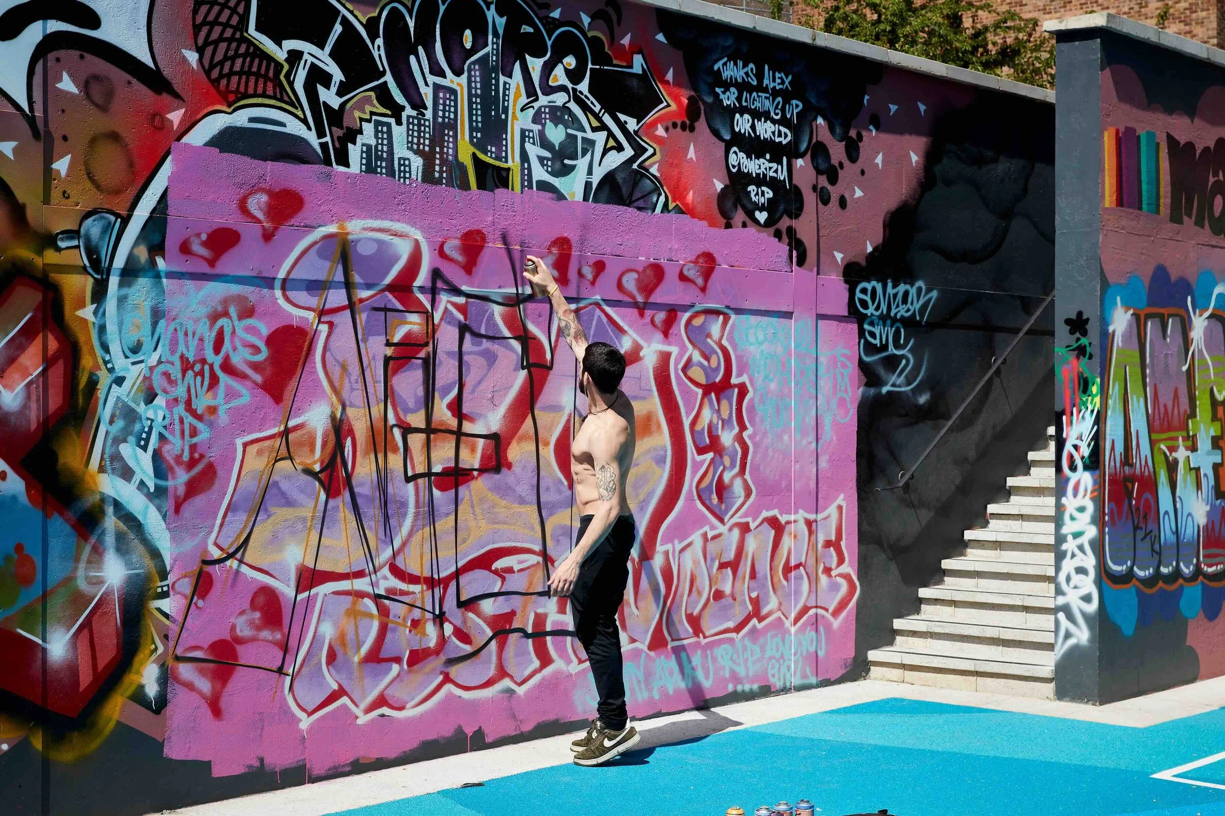 artist spray paint the walls of the ball court