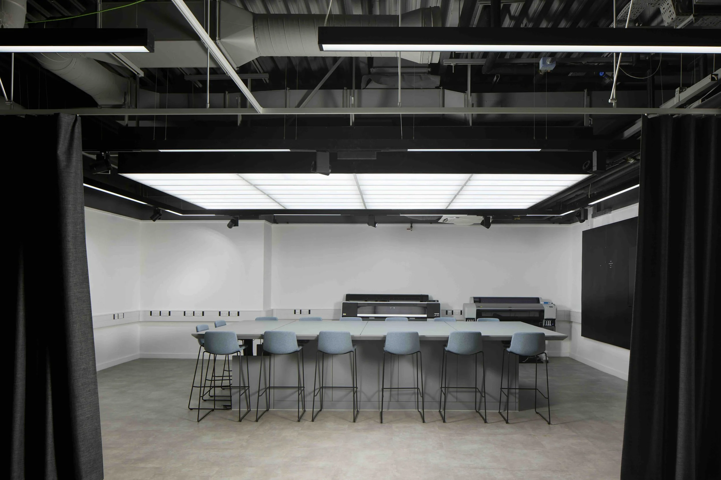 Rock Townsend Architects LLP — The Photographic Studio, Harrow Campus, University Of Westminster - Large meeting room with a long table, blue chairs, and large format printers again